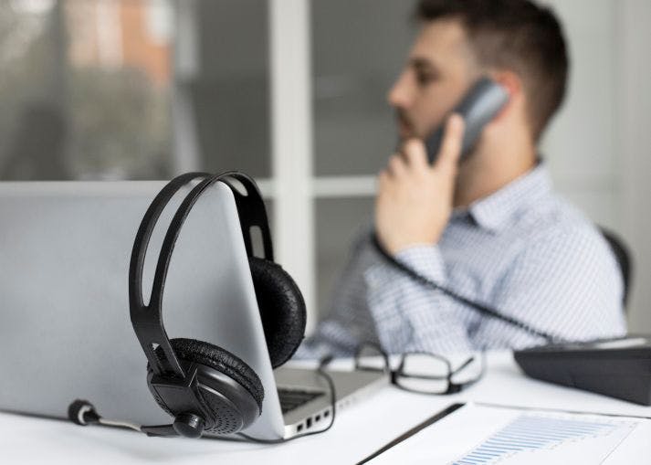 homme utilisant sa téléphonie professionnelle au bureau