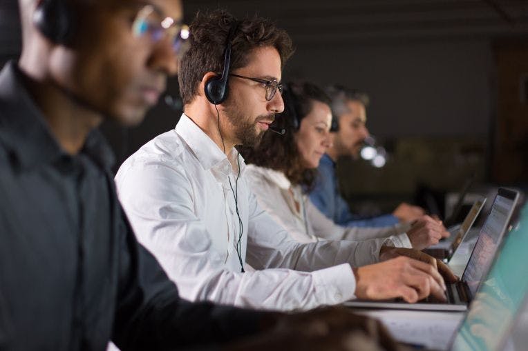 image d'un centre d'appels, personnes avec des casques