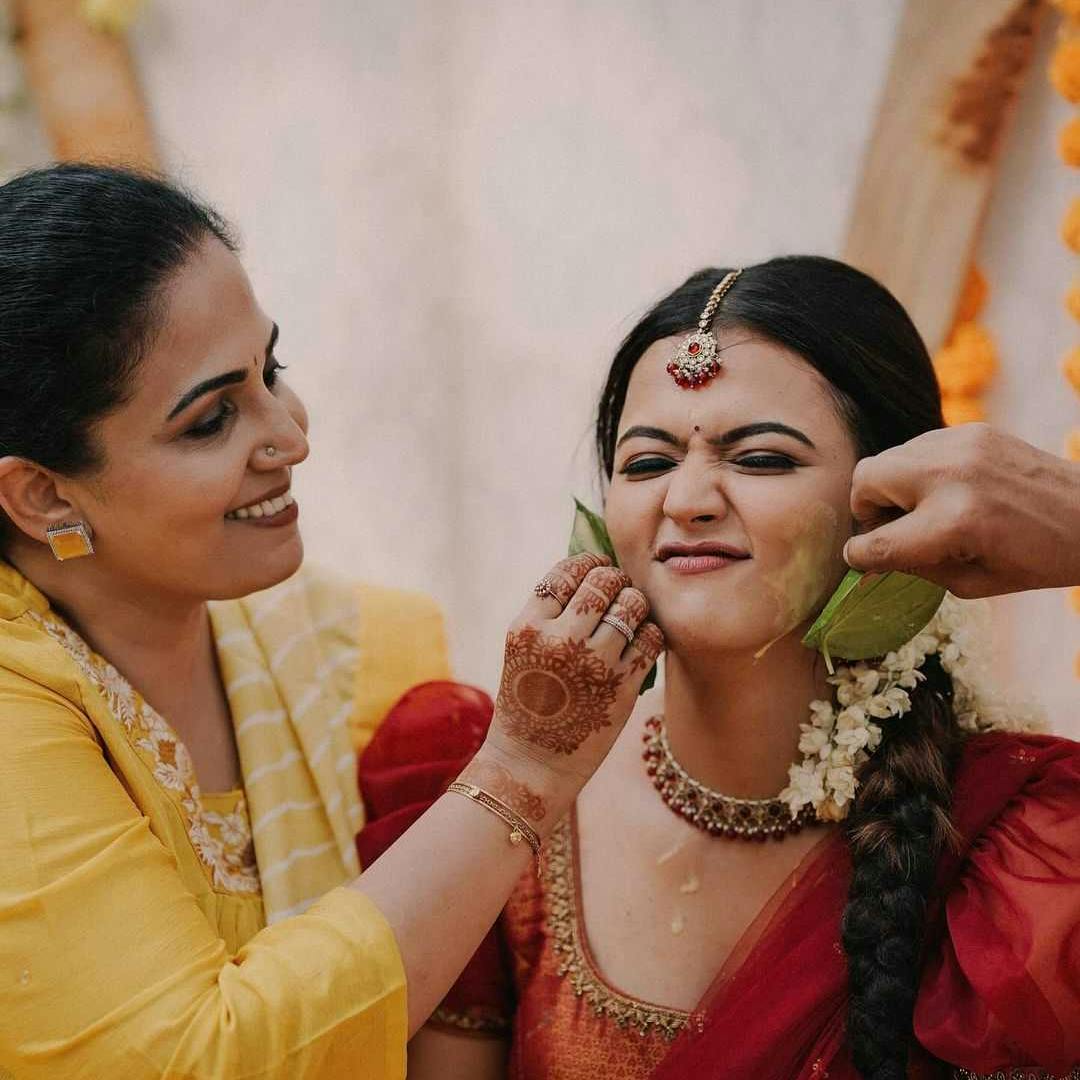 Friends applying haldi on bride photo