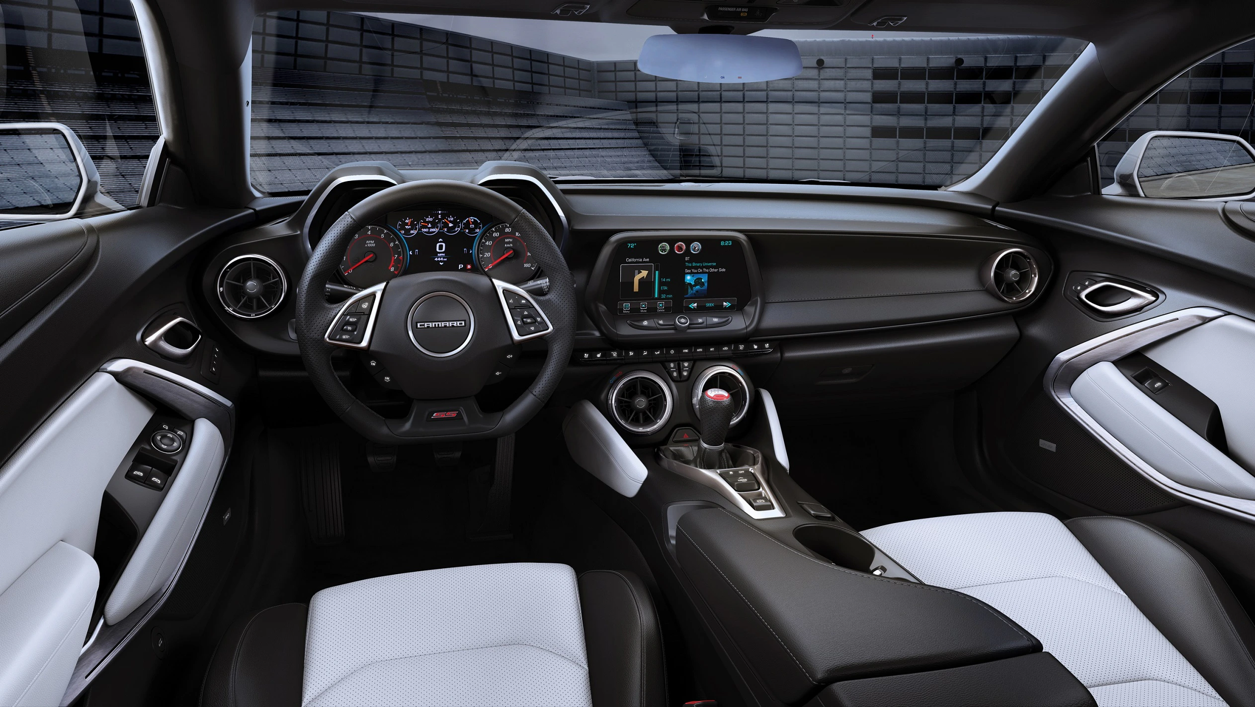 Innenraum eines modernen Autos mit sportlichem Lenkrad, großem Touchscreen-Display und schwarzen sowie weißen Sitzen und Armaturen.