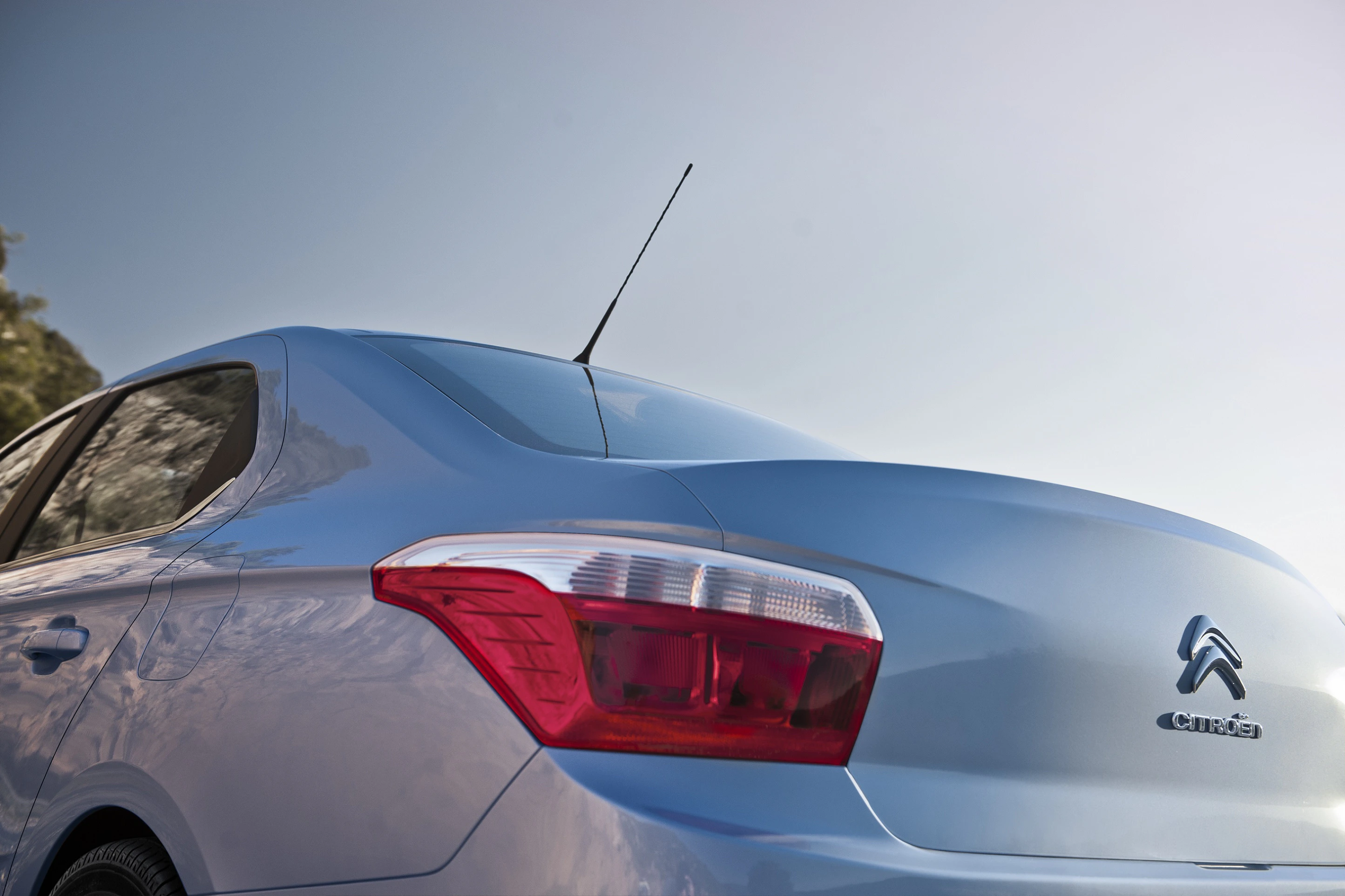 Nahaufnahme eines blauen Citroën C-Elysée von hinten mit klarem Himmel im Hintergrund.