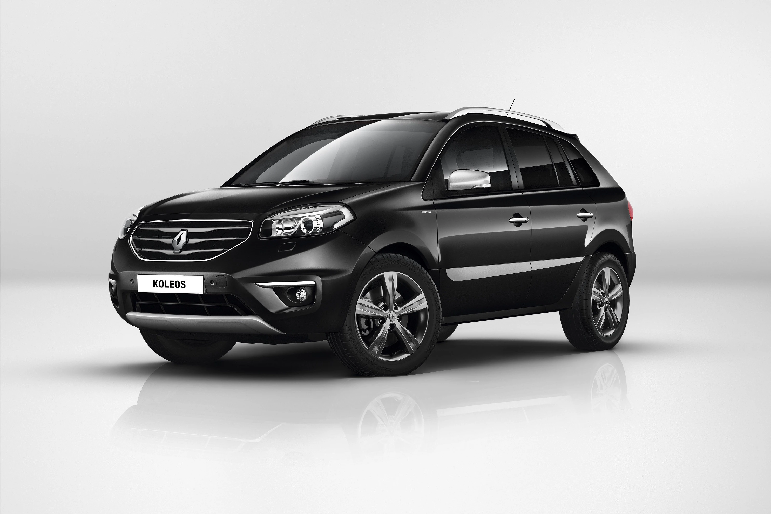 Schwarzer Renault Koleos SUV vor weißem Hintergrund, schräg von vorne fotografiert. Elegantes Design mit silbernen Akzenten.