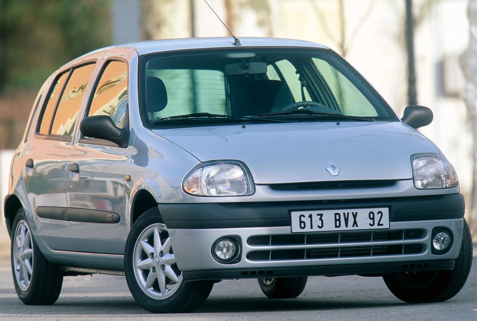 Silberner Renault Clio, fünftürig, steht auf einer Straße. Die Sonne reflektiert leicht auf der Karosserie.