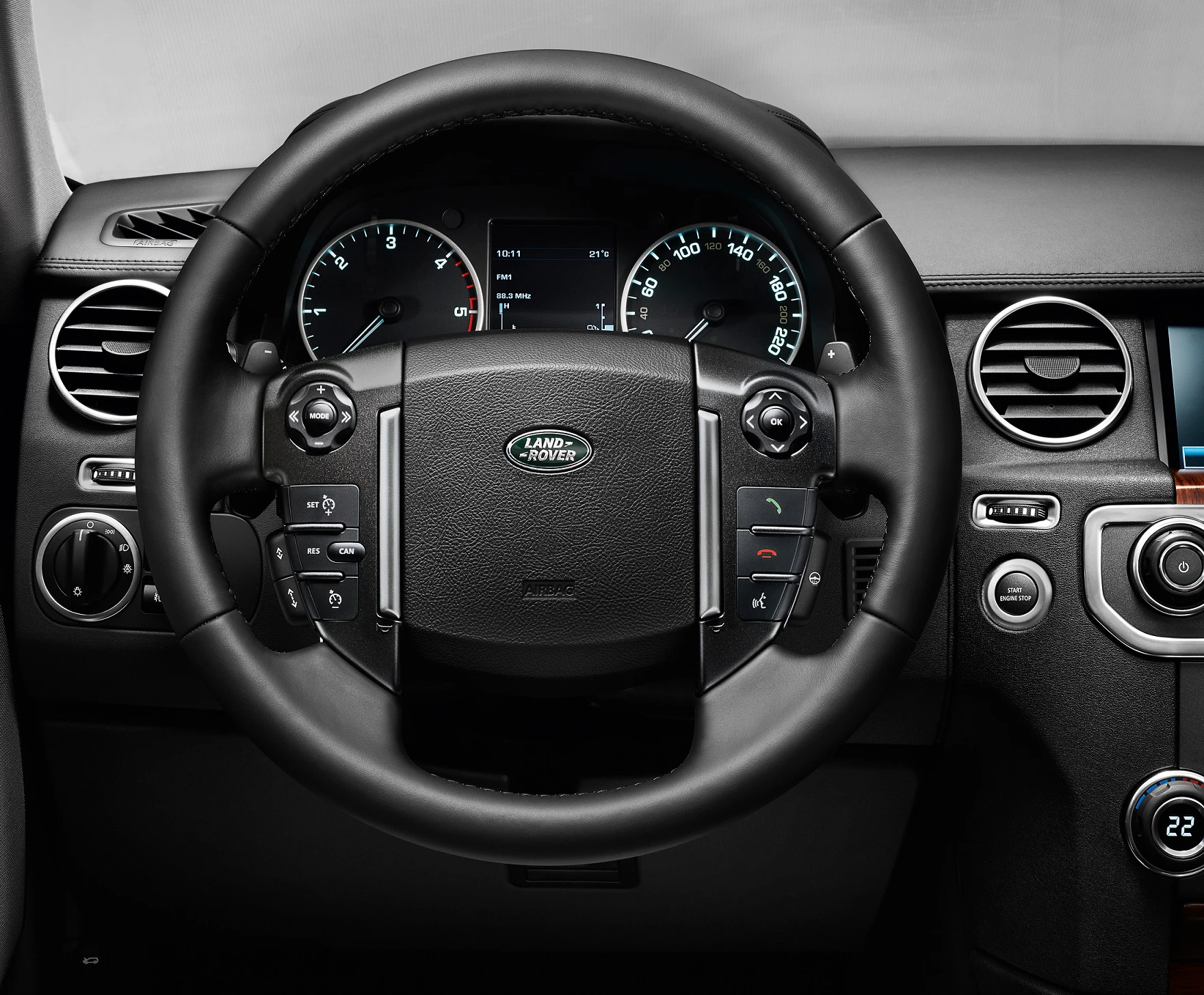 Nahaufnahme eines Land Rover Lenkrads mit Armaturenbrett. Sichtbare Bedienelemente und Anzeigen hinter dem Lenkrad.