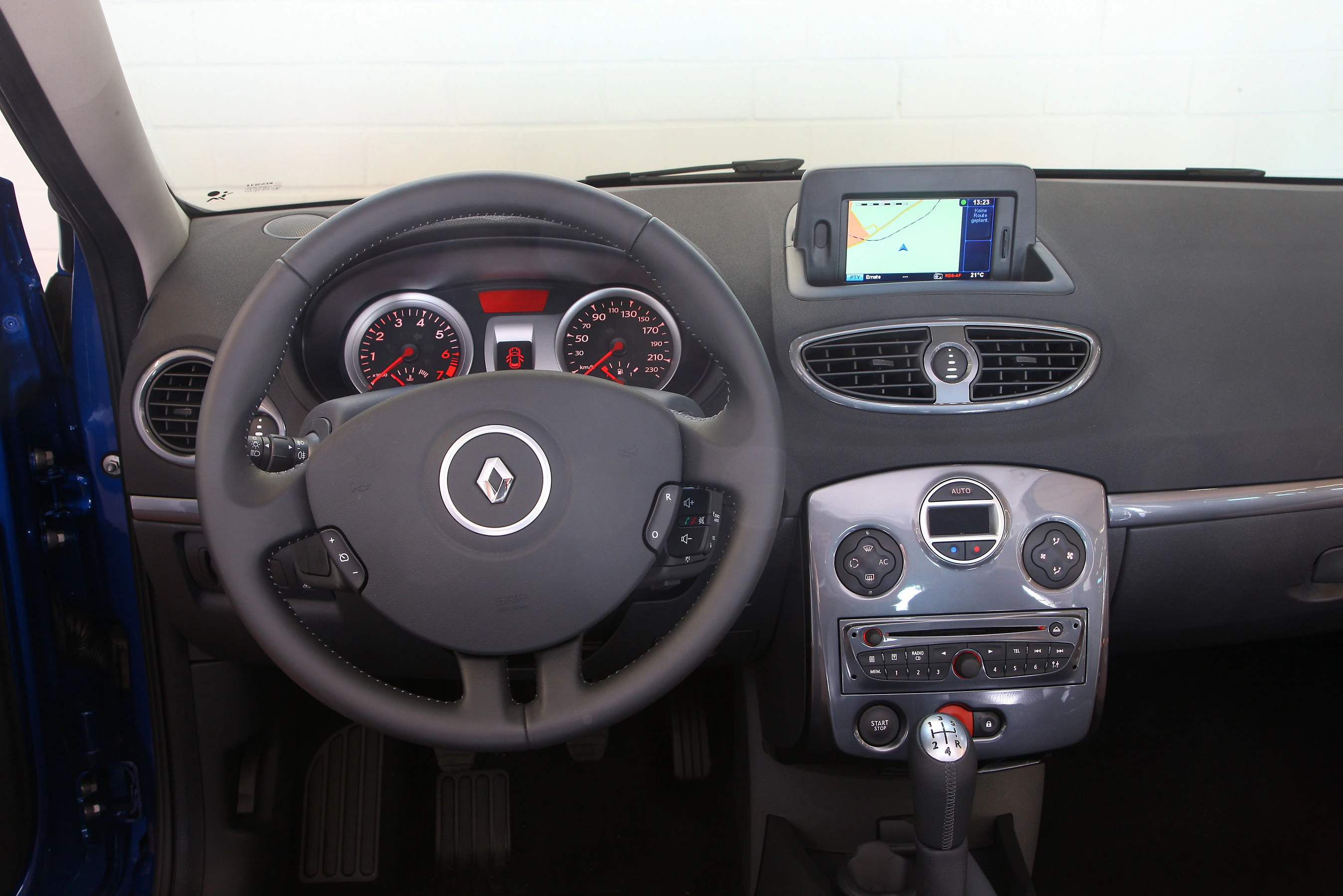 Armaturenbrett eines Renaults mit Lenkrad, Tachometer, Belüftungsschlitzen und eingebautem Navigationssystem auf der Mittelkonsole.