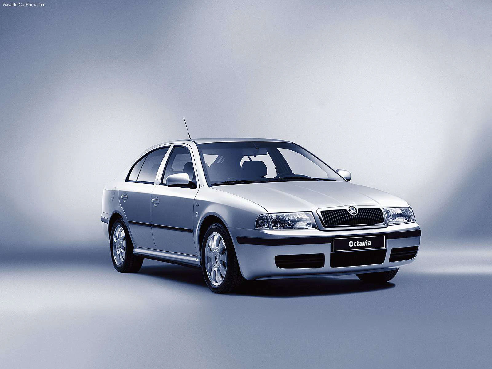Silberner Škoda Octavia Limousine, seitlich von vorne fotografiert, vor einem grauen Hintergrund.
