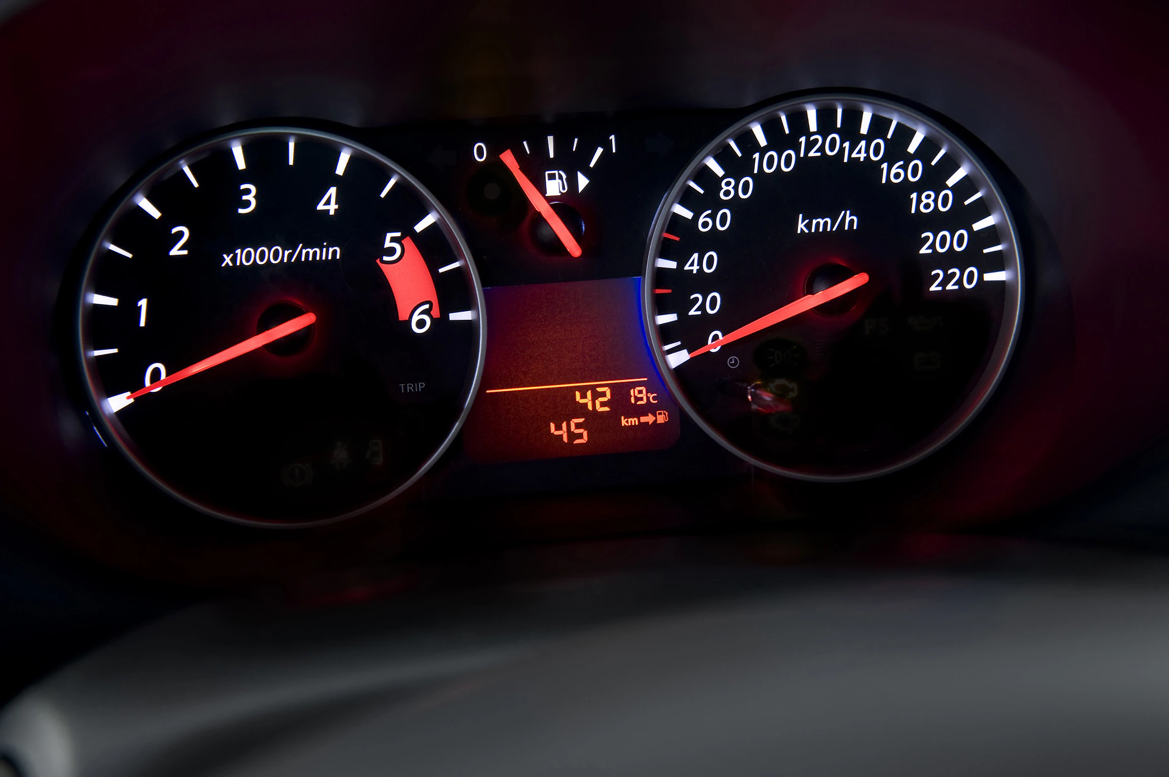 Nahaufnahme eines Auto-Armaturenbretts mit Tachometer, Drehzahlmesser, Tankanzeige und digitaler Anzeige mit Außentemperatur und Kilometerstand.