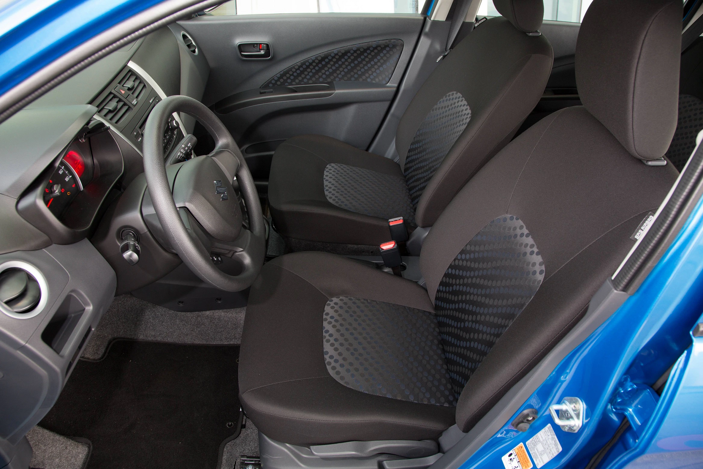 Innenraum eines blauen Autos mit schwarzen Sitzen, grauen Akzenten und einem modernen Armaturenbrett. Fahrersitz und Beifahrersitz sichtbar.
