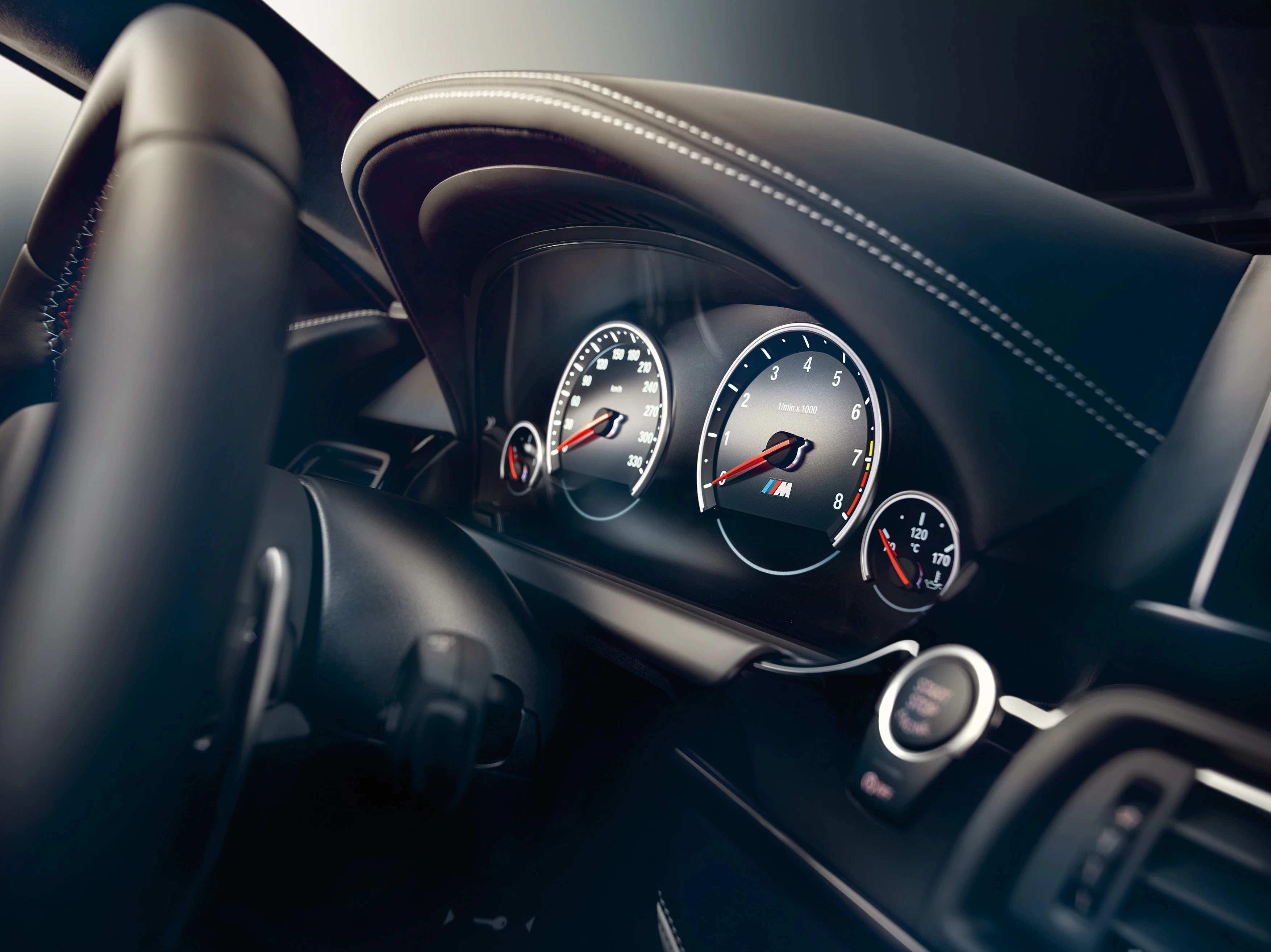 Nahaufnahme eines Auto-Cockpits mit Tachometer und Drehzahlmesser. Schwarzes Lenkrad, stilvolles Armaturenbrett mit weißen Nähten.