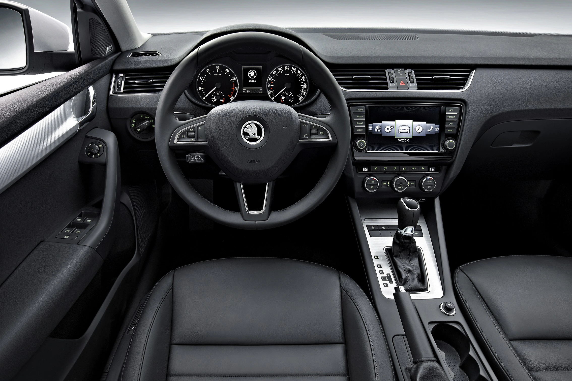 Innenraum eines Autos: schwarzes Lenkrad mit Skoda-Logo, Armaturenbrett mit Tacho und Digitalanzeige, Mittelkonsole mit Schalthebel.