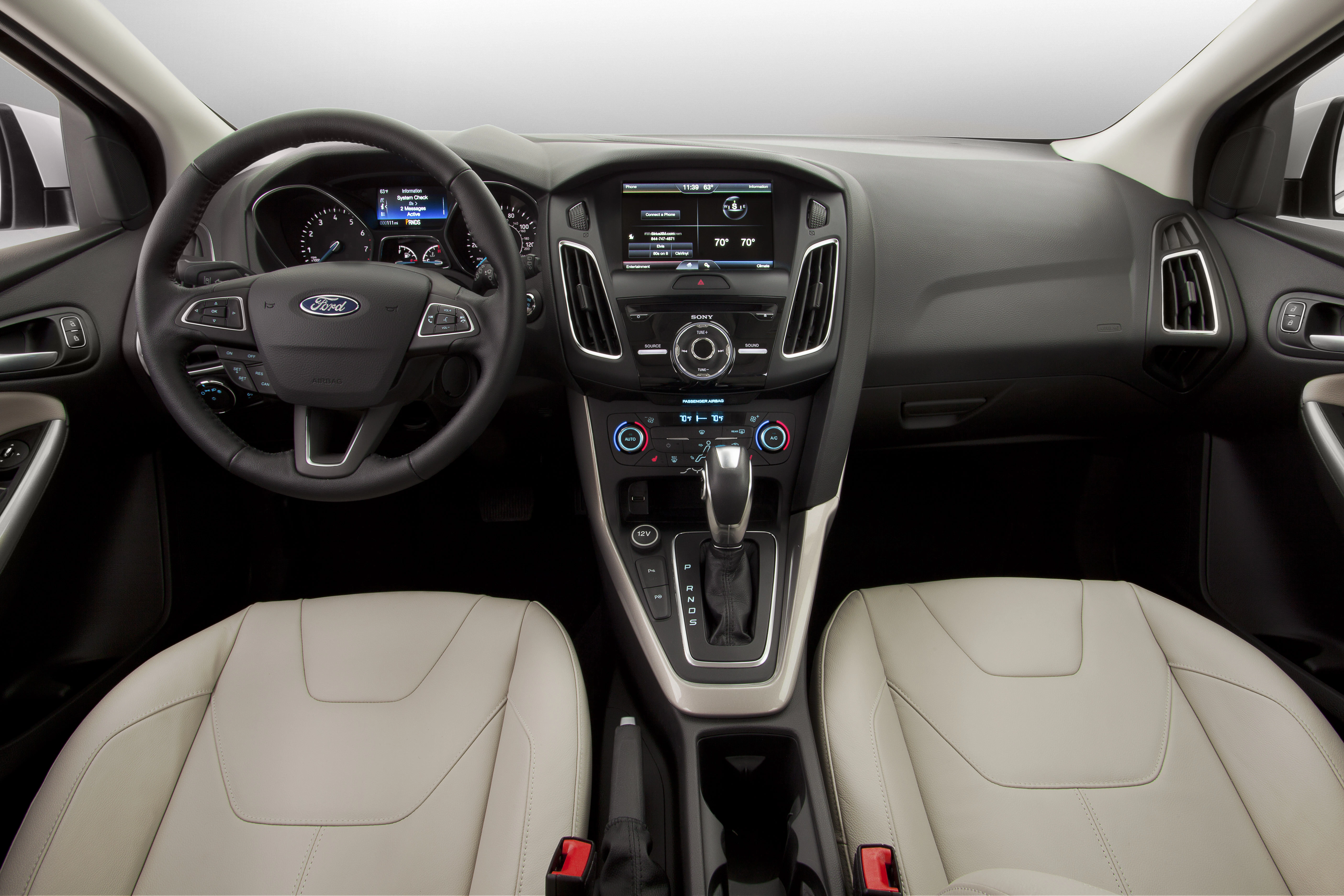 Innenraum eines modernen Autos mit Leder-Vordersitzen, Lenkrad mit Ford-Logo, Touchscreen-Display und Bedienelementen auf der Mittelkonsole.