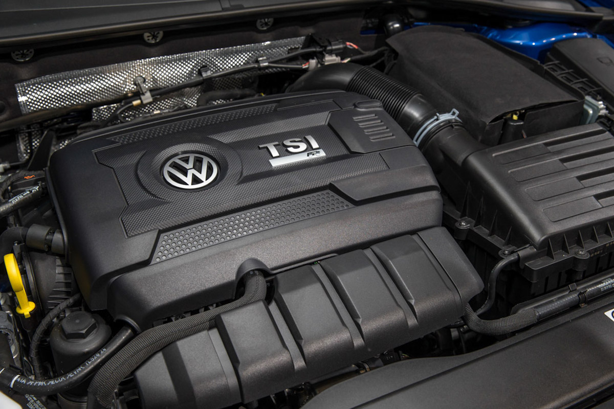 Volkswagen TSI-Motor in einem Fahrzeug. Sichtbar sind Motorkomponenten und das VW-Logo auf der Abdeckung.