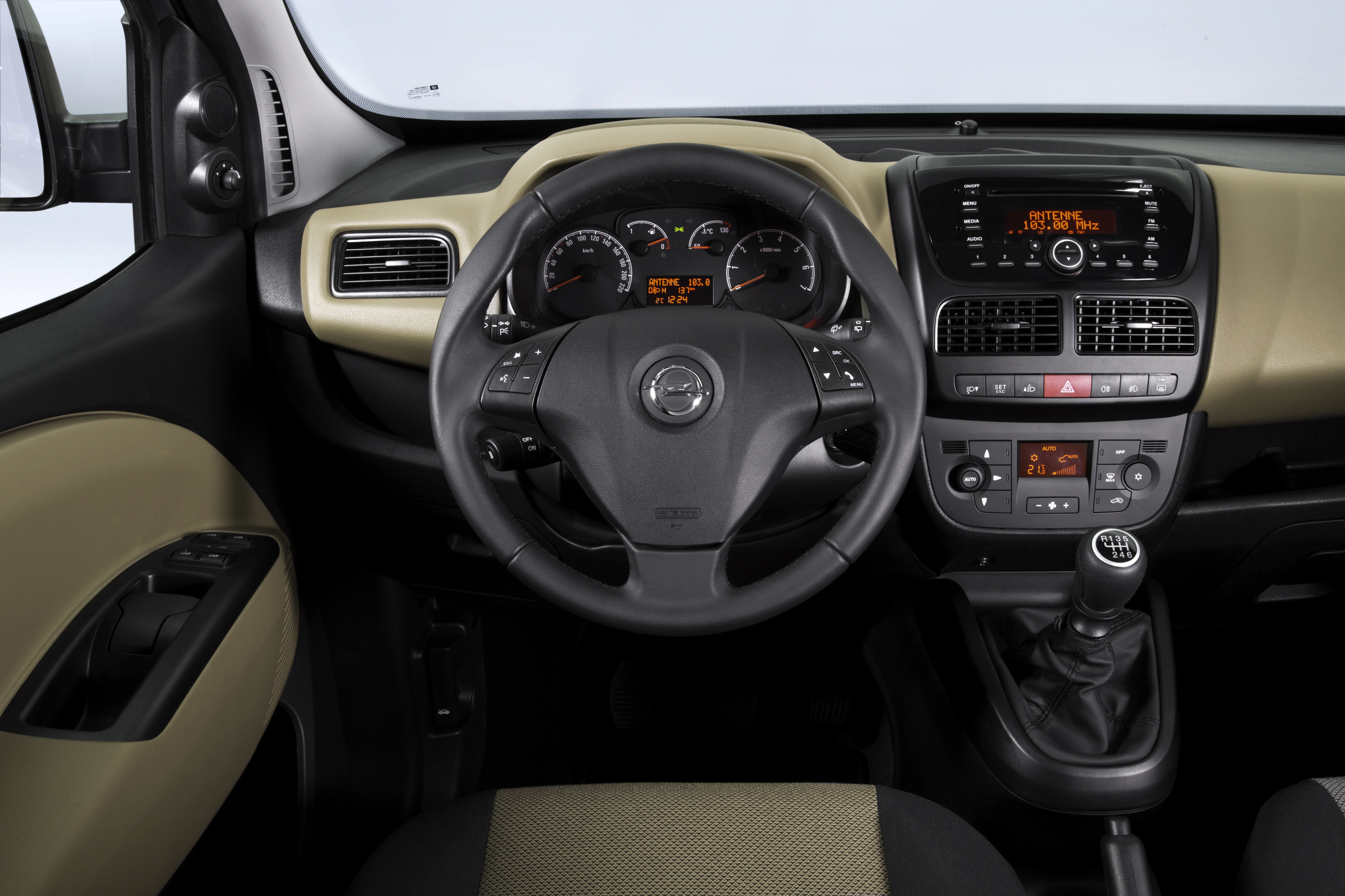 Innenraum eines Autos mit Lenkrad, Armaturenbrett und Schalthebel. Moderne Anzeigeinstrumente und Bedienelemente sichtbar.
