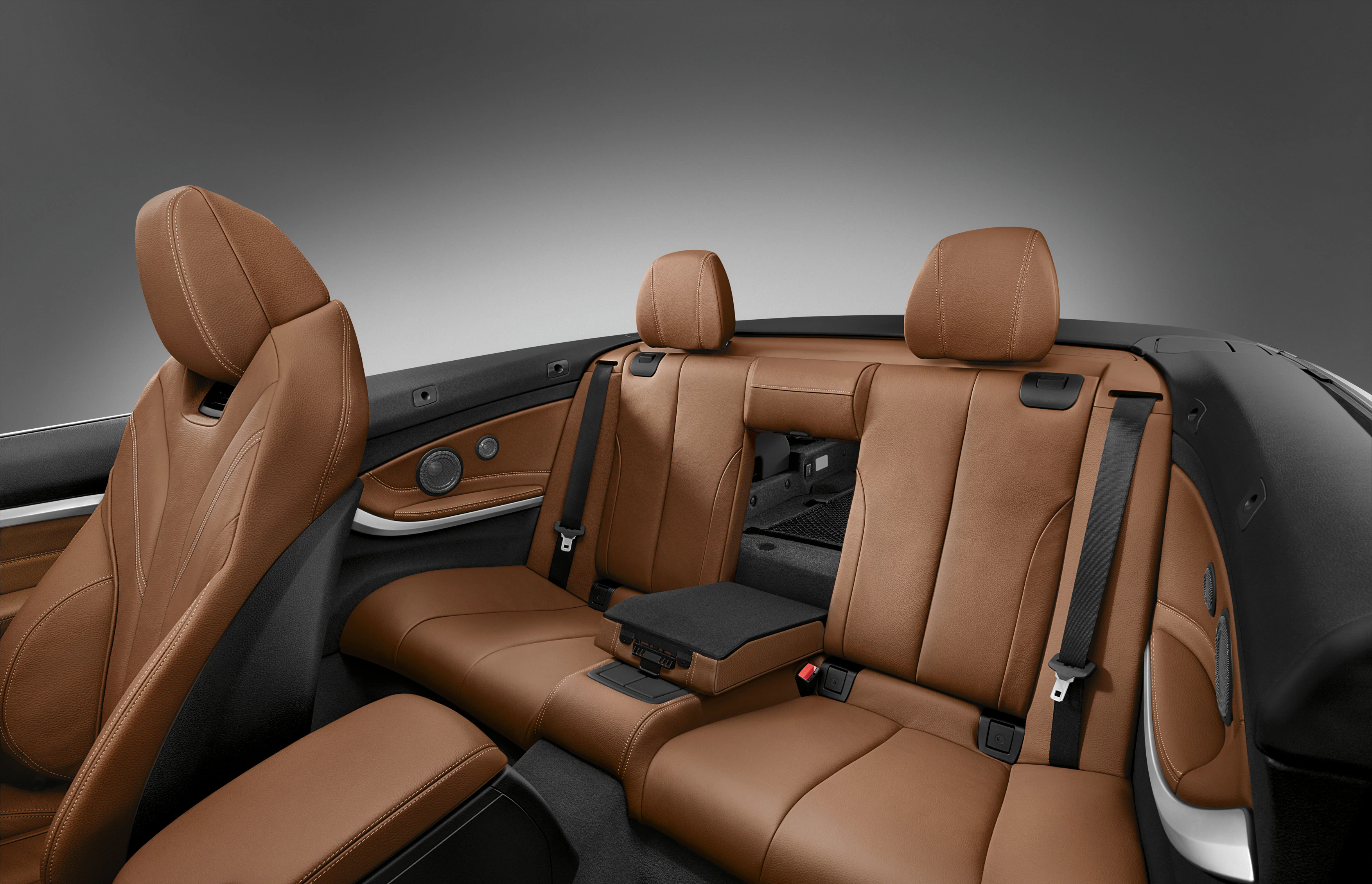 Brauner Ledersitz im Innenraum eines Autos. Elegantes Design mit Mittelarmlehne und Kopflehnen, umgeben von einer stilvollen, modernen Ausstattung.