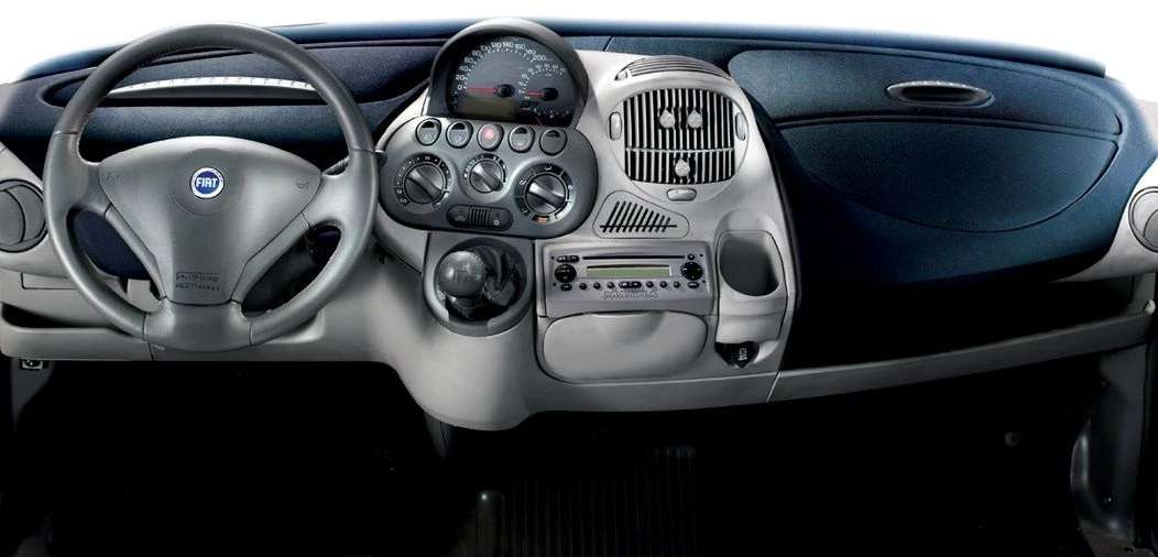 Armaturenbrett eines Fiat Multipla mit Lenkrad, Tachometer, Lüftungsschlitzen und Audioanlage. Modernes Design mit geschwungenen Linien.