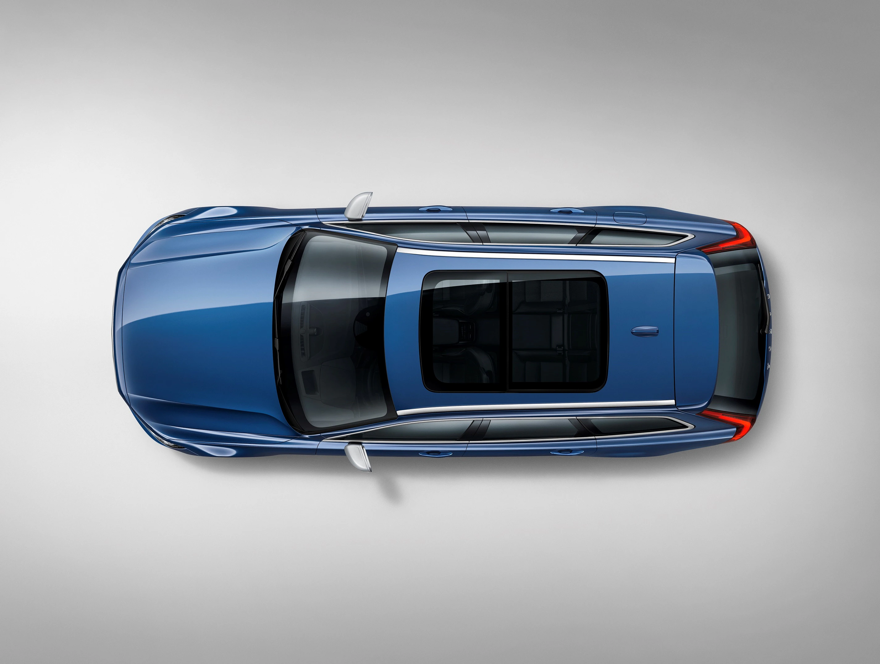 Blaues Auto von oben mit großem Panoramadach, auf grauem Hintergrund fotografiert.