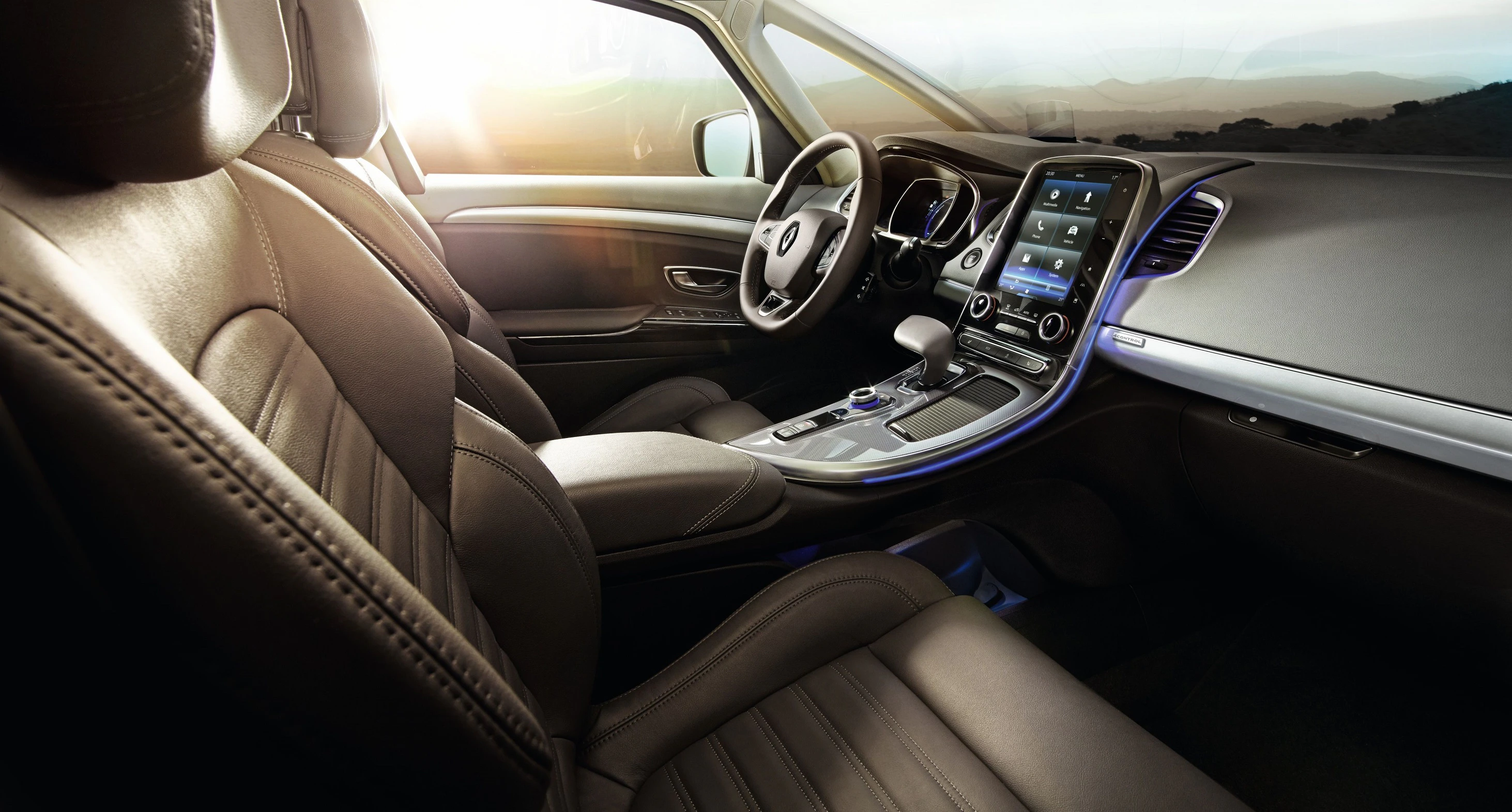 Innenraum eines modernen Autos mit Ledersitzen, großem Touchscreen-Display auf der Mittelkonsole und Panoramaglasdach, beleuchtet durch Sonnenlicht.