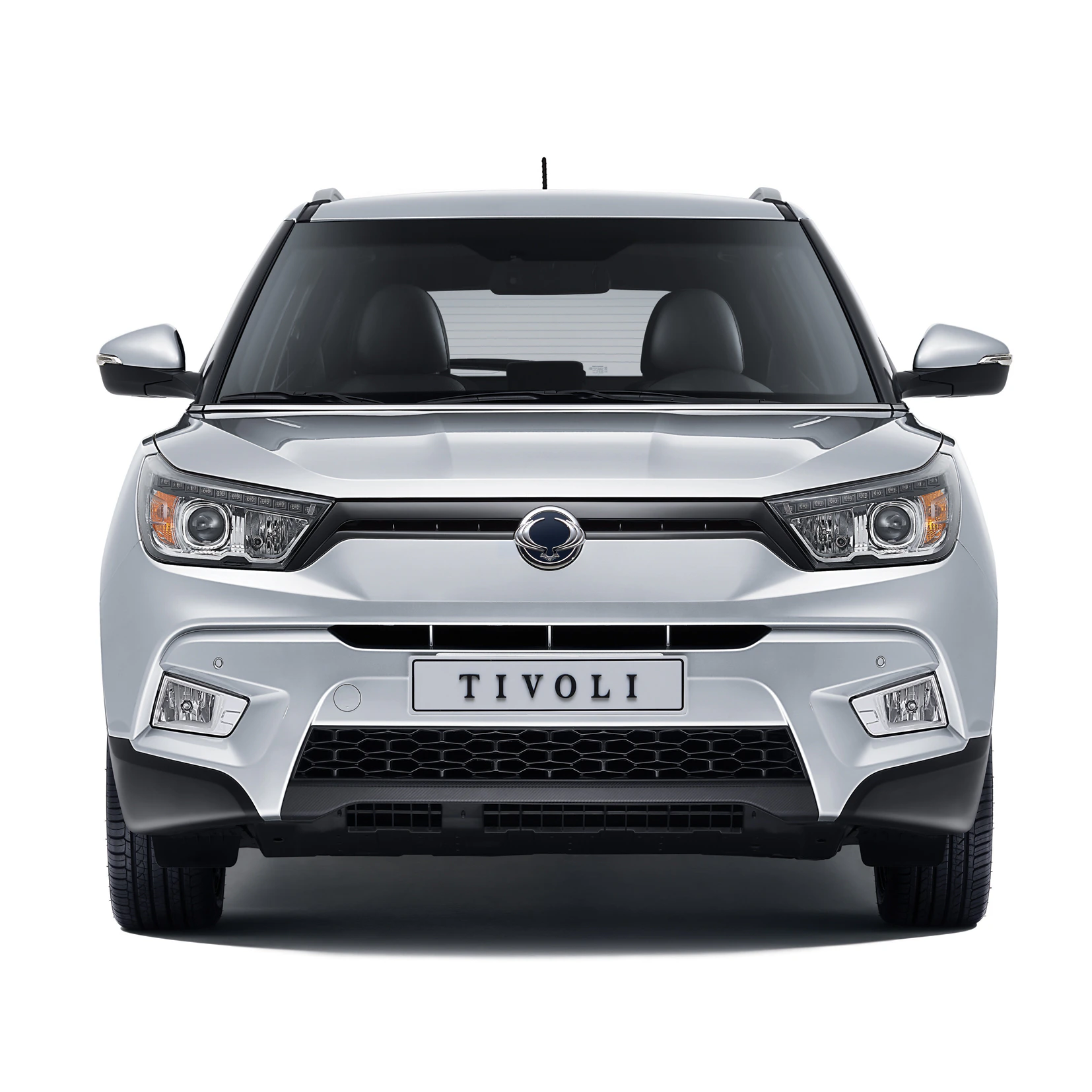 Frontansicht eines weißen Autos mit der Aufschrift "Tivoli" auf dem Nummernschild, gut sichtbare Scheinwerfer und Kühlergrill.