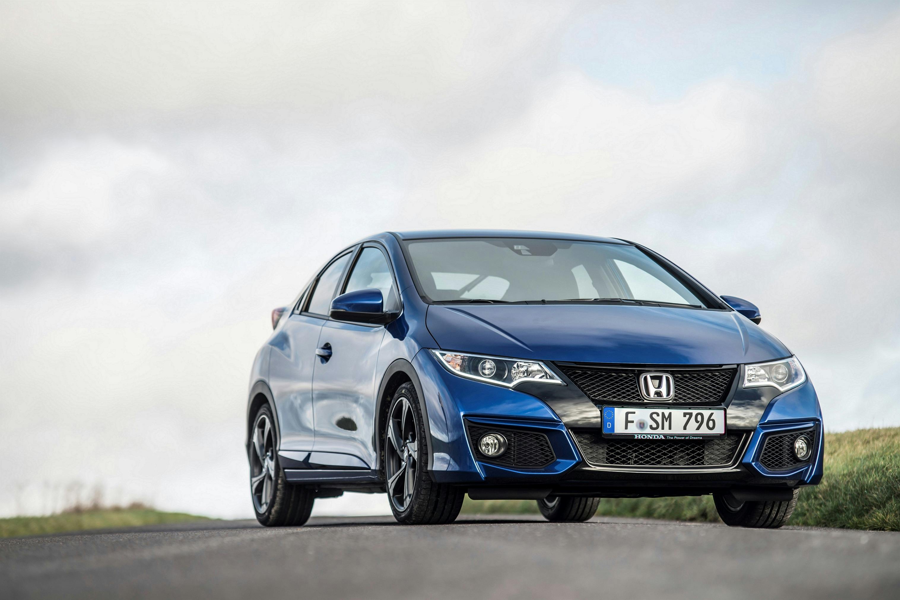 Blauer Honda Civic parkt auf einer Straße vor einem bewölkten Himmel. Das Auto hat Sportfelgen und eine markante Front.