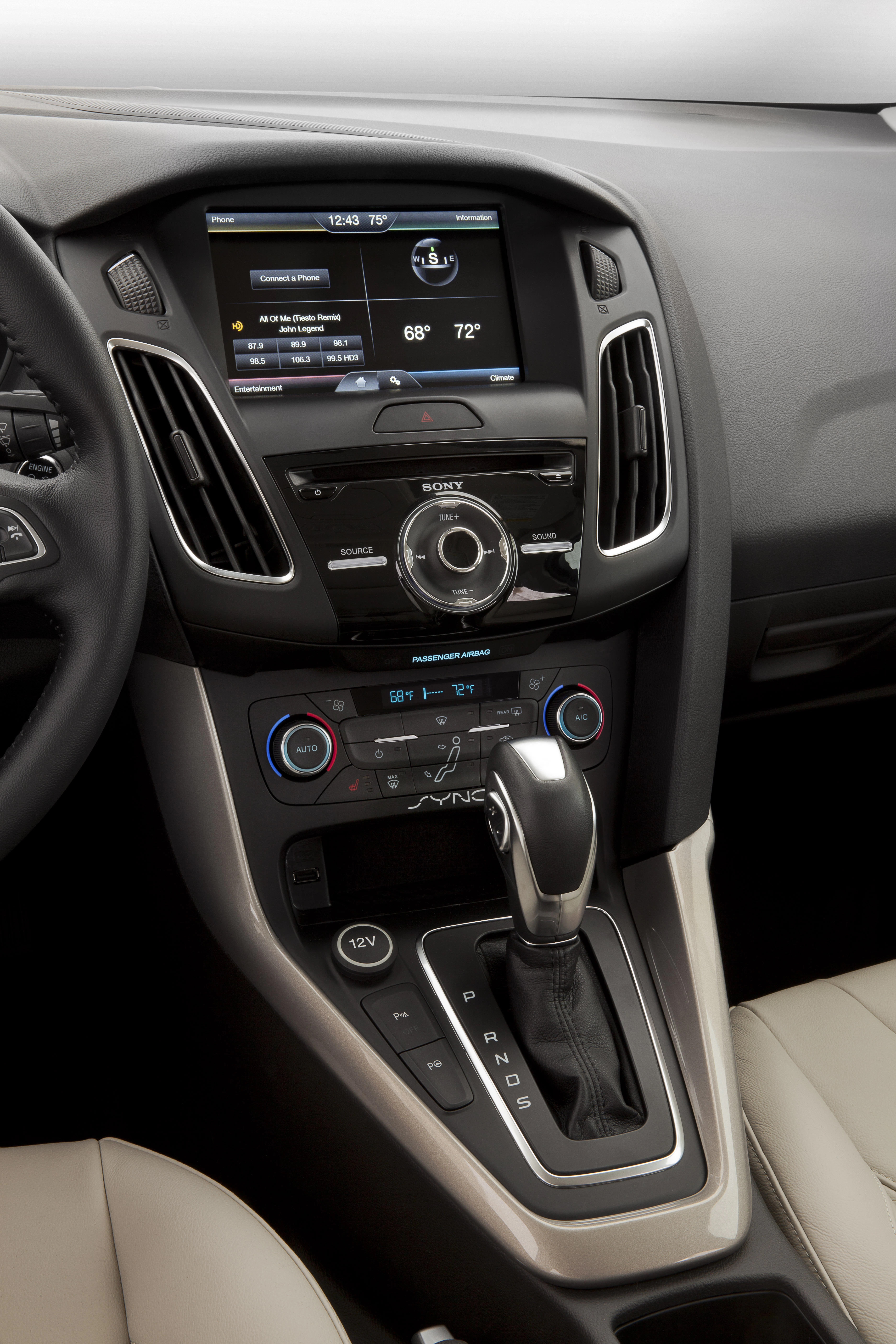 Nahaufnahme eines modernen Auto-Innenraums mit Touchscreen-Display, Klimasteuerung und Automatikgetriebehebel.