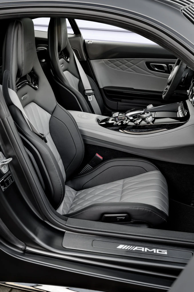 Innenraum eines luxuriösen Sportwagens mit grauen Ledersitzen, einem stilvollen Armaturenbrett und AMG-Logo auf der Einstiegsleiste.