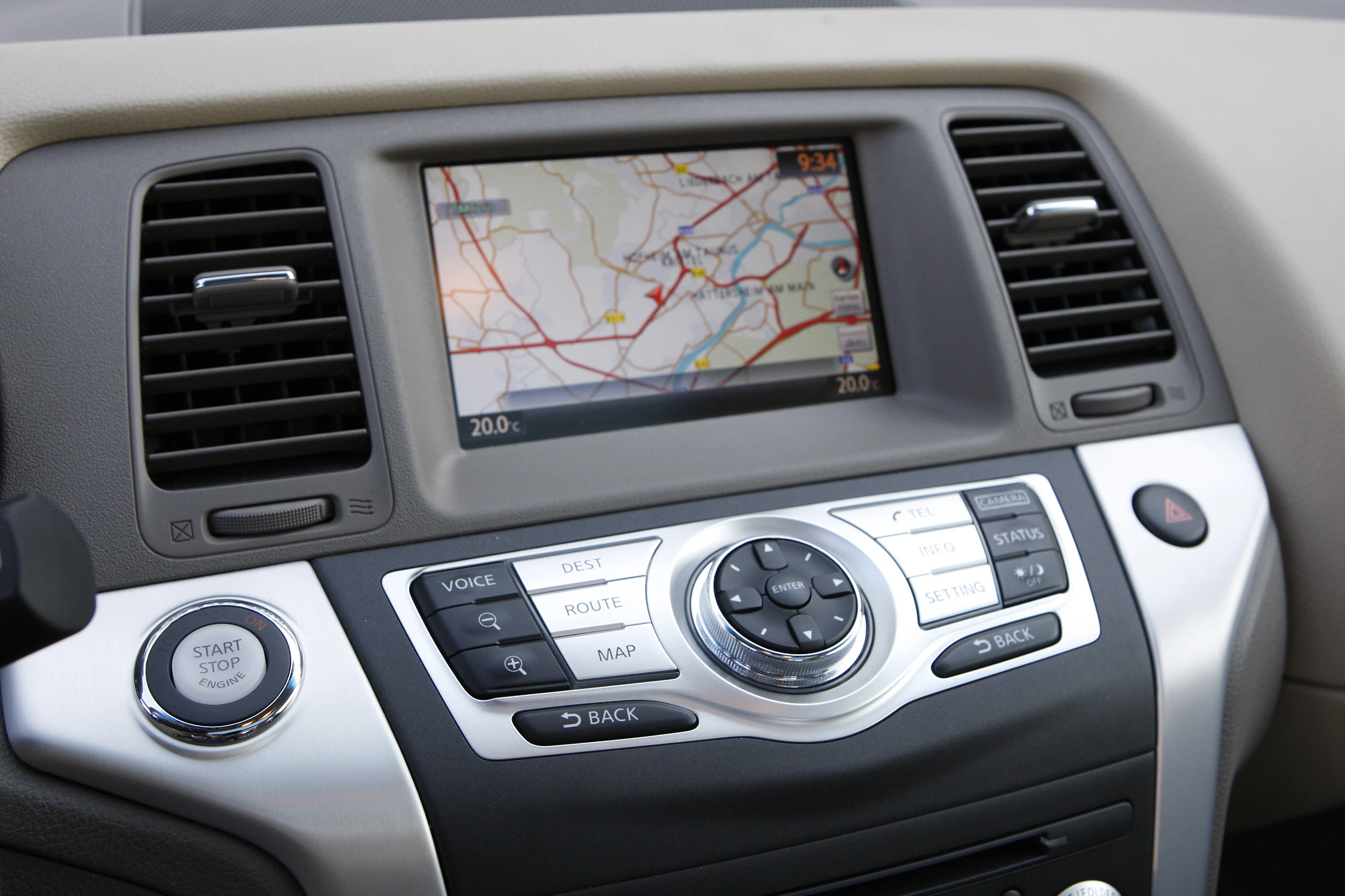 Nahaufnahme eines Autonavigationssystems mit Farbbildschirm, zeigt eine Straßenkarte. Darunter befinden sich Tasten zur Steuerung des Systems.