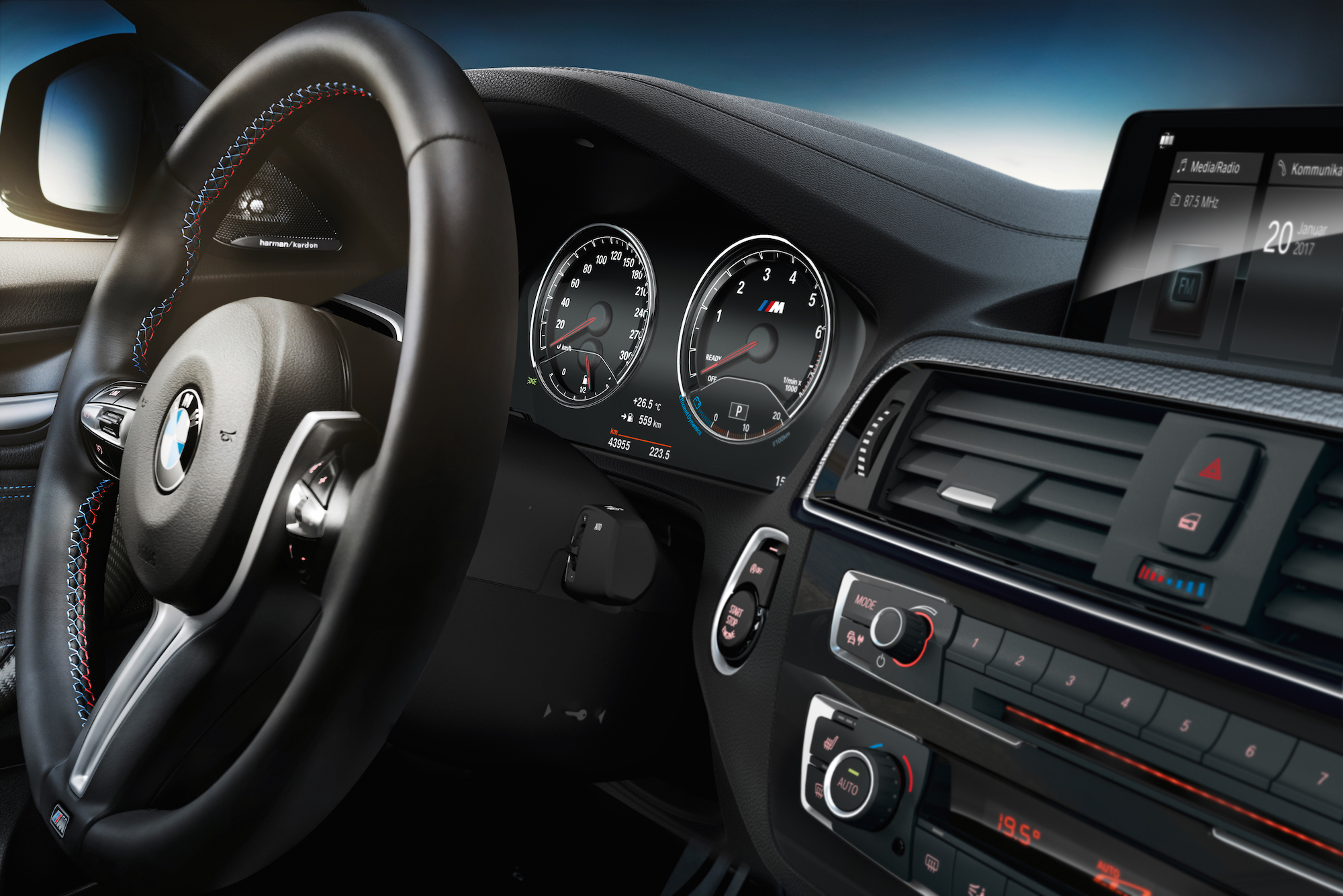 Nahaufnahme eines BMW-Autos. Zeigt Lenkrad, Tachometer und Fahrzeugdisplay mit modernen Bedienelementen und Anzeigeelementen.