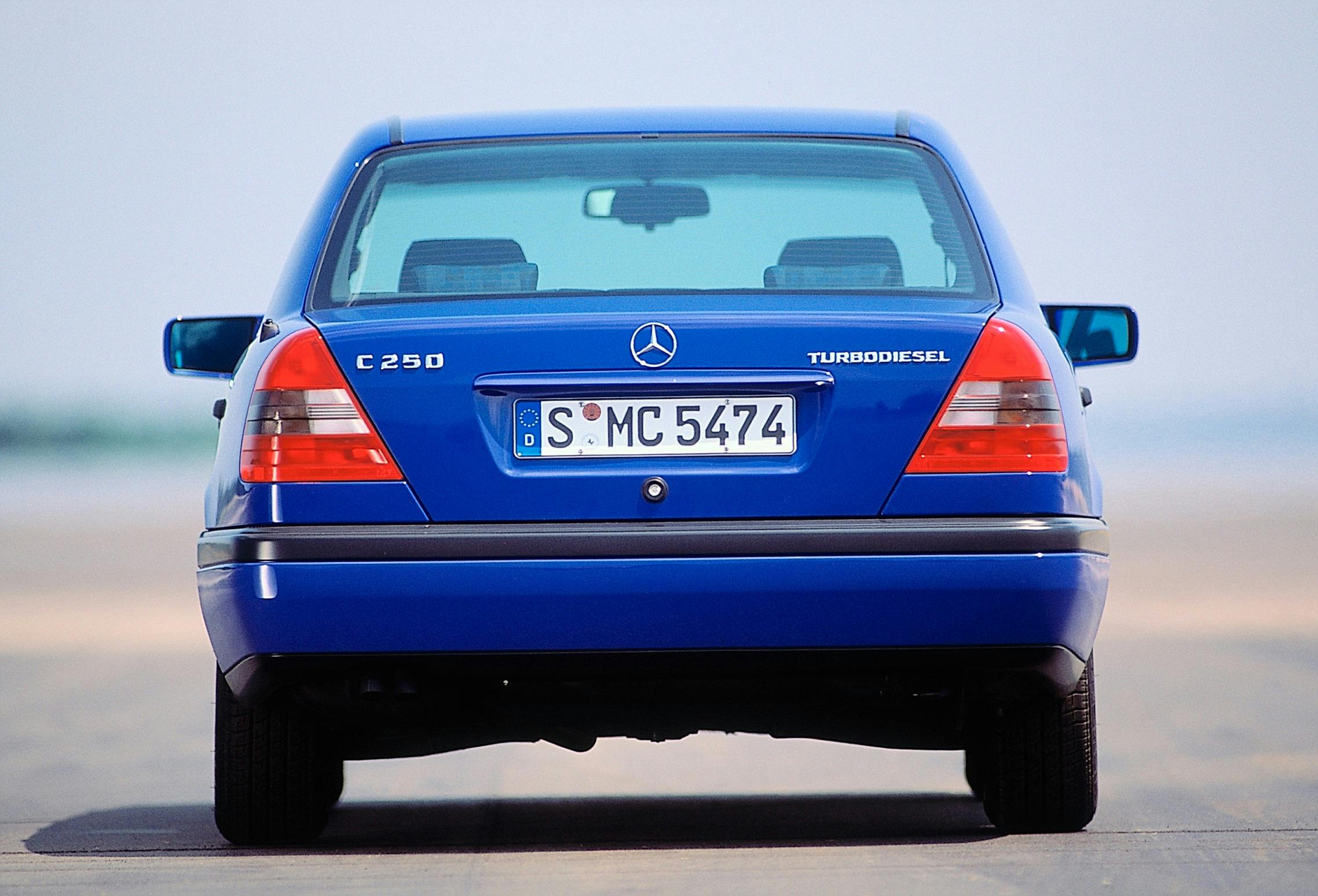 Blauer Mercedes C250 Turbodiesel, Heckansicht auf einer Straße, mit deutschem Kennzeichen. Klarer Himmel im Hintergrund.