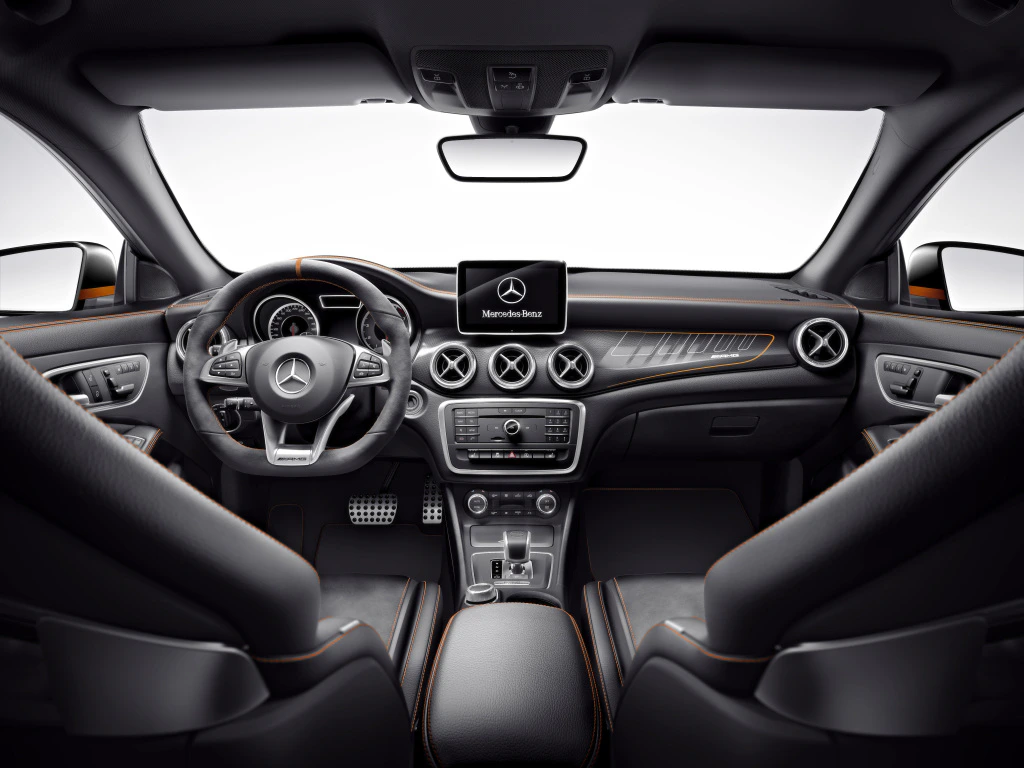 Innenansicht eines modernen Mercedes-Benz mit Lenkrad, zentralem Bildschirm, Lüftungsschlitzen und hochwertiger Ausstattung in Schwarz-Grau.