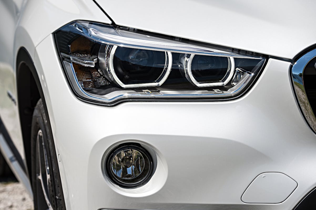 Nahaufnahme eines silbernen Autos mit Fokus auf den modernen Scheinwerfer und die runden Nebelscheinwerfer.