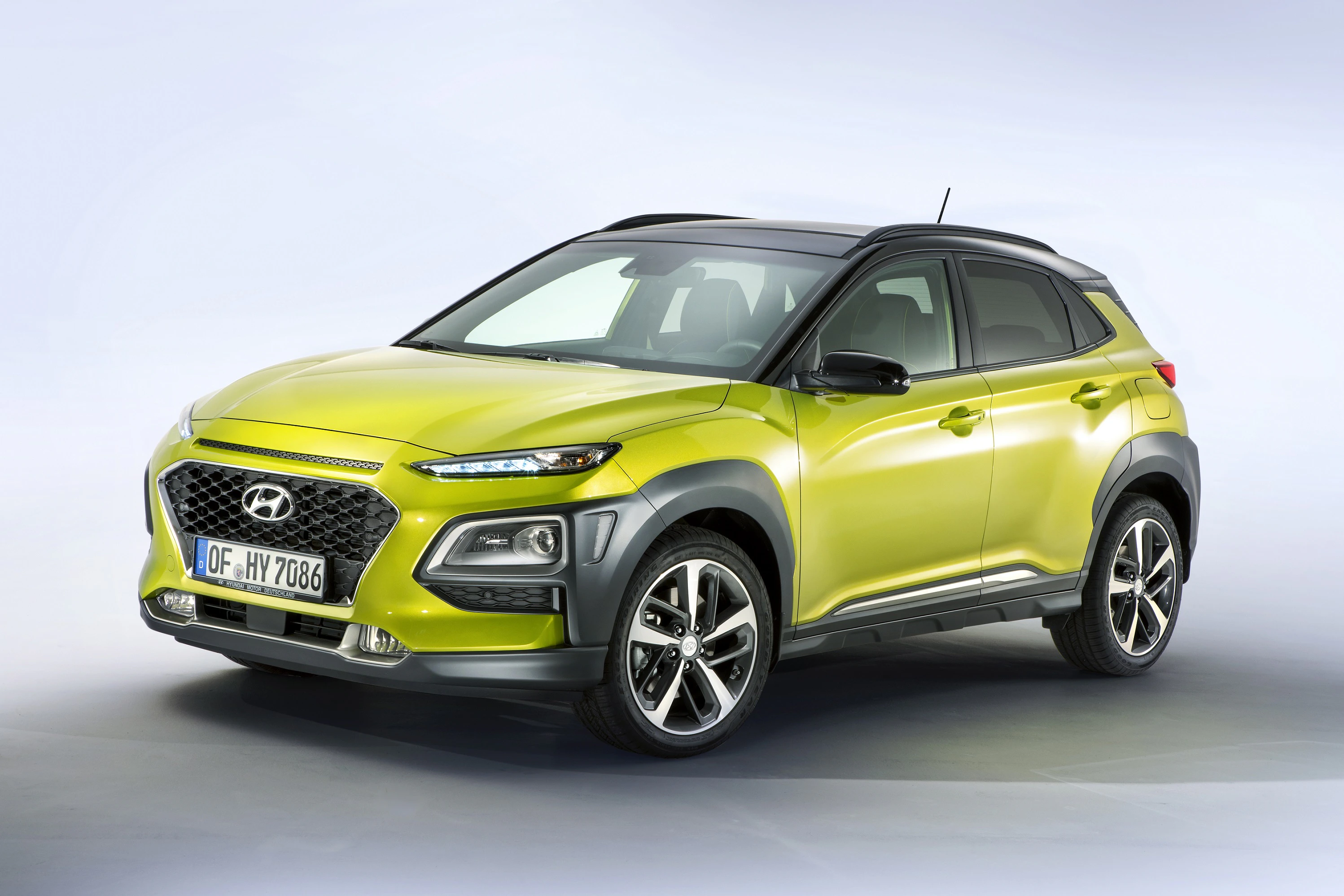 Grüner SUV mit modernen LED-Scheinwerfern in einem Studio. Fahrzeugmarke auf dem Kühlergrill, deutsches Kennzeichen vorne.