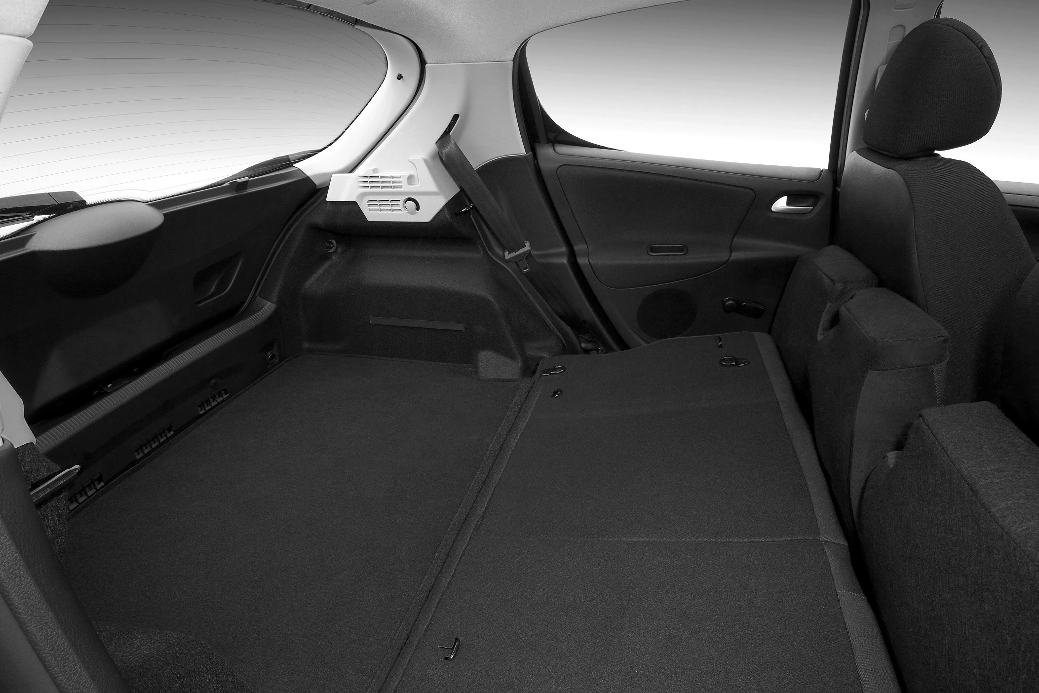 Innenraum eines Autos mit umgeklappten Rücksitzen, um den Kofferraum zu vergrößern. Dunkler Stoffbezug, modernes Design.