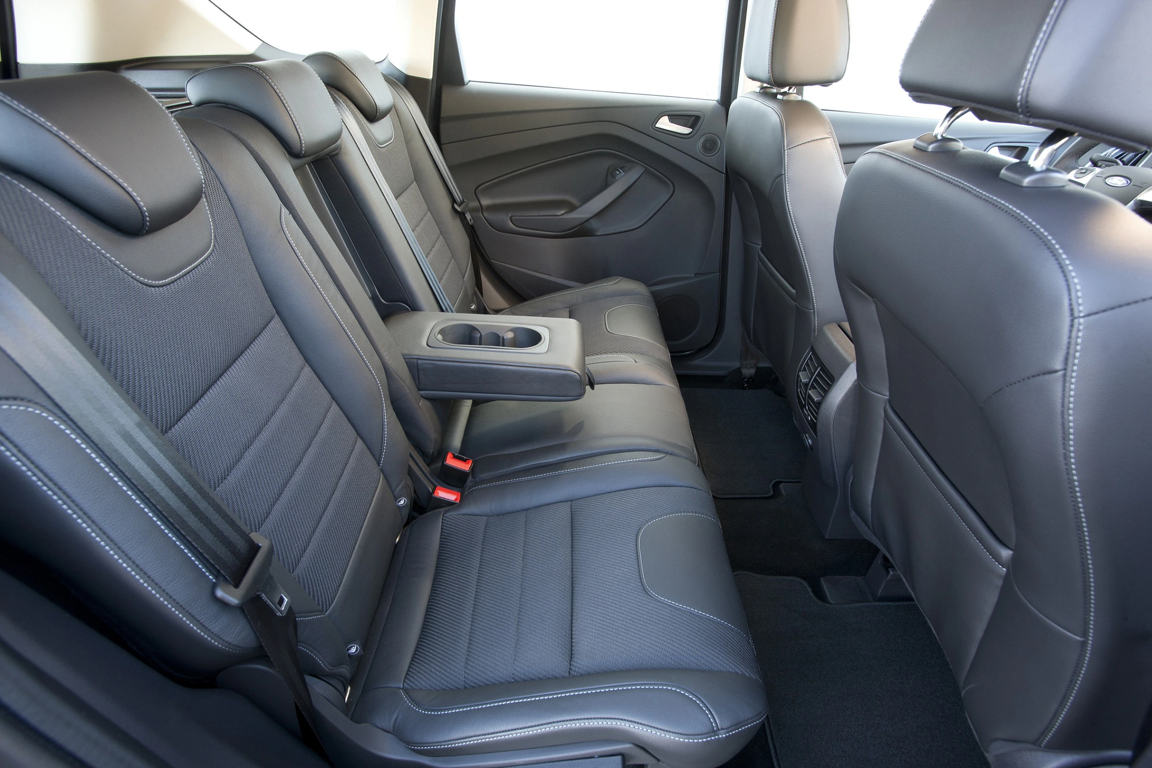 Rückansicht eines Autos mit drei schwarzen Ledersitzen und Armlehne in der Mitte, moderne Innenausstattung.