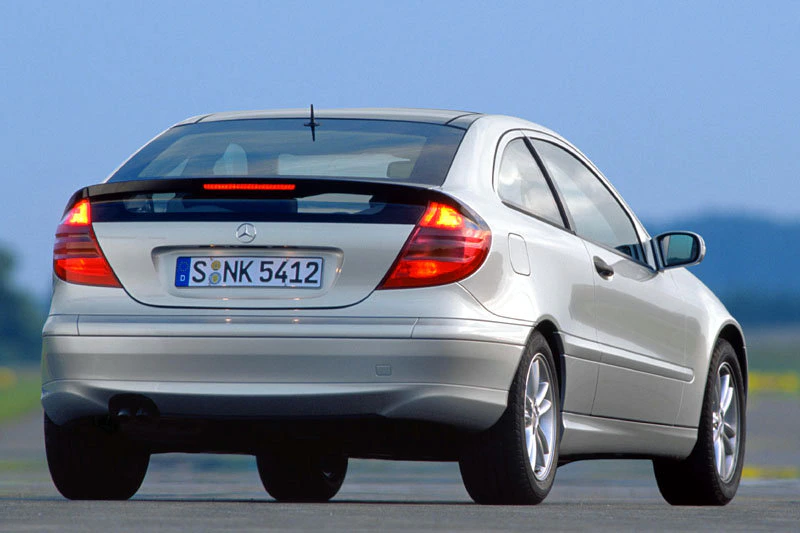 Silberner Mercedes-Benz von hinten auf einer Straße, erkennbar an Rücklichtern und Nummernschild.