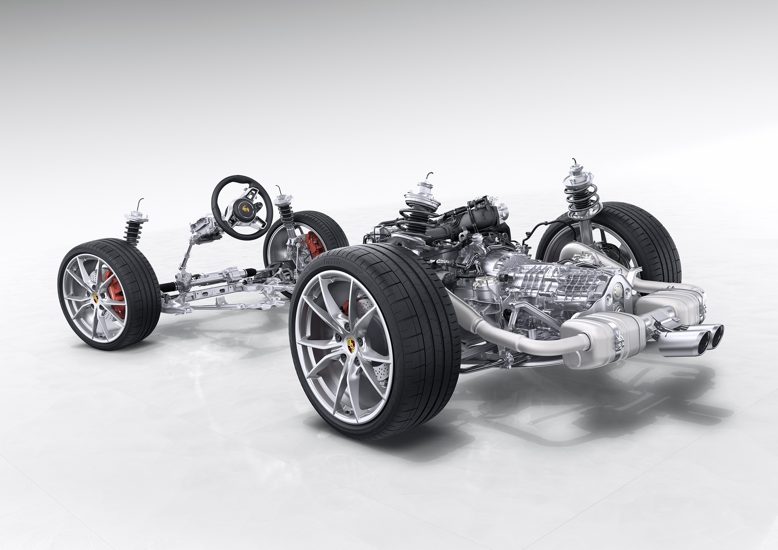 Fahrwerk und Antrieb eines Autos mit sichtbaren Rädern, Federung und Lenkung, vor einem grauen Hintergrund.