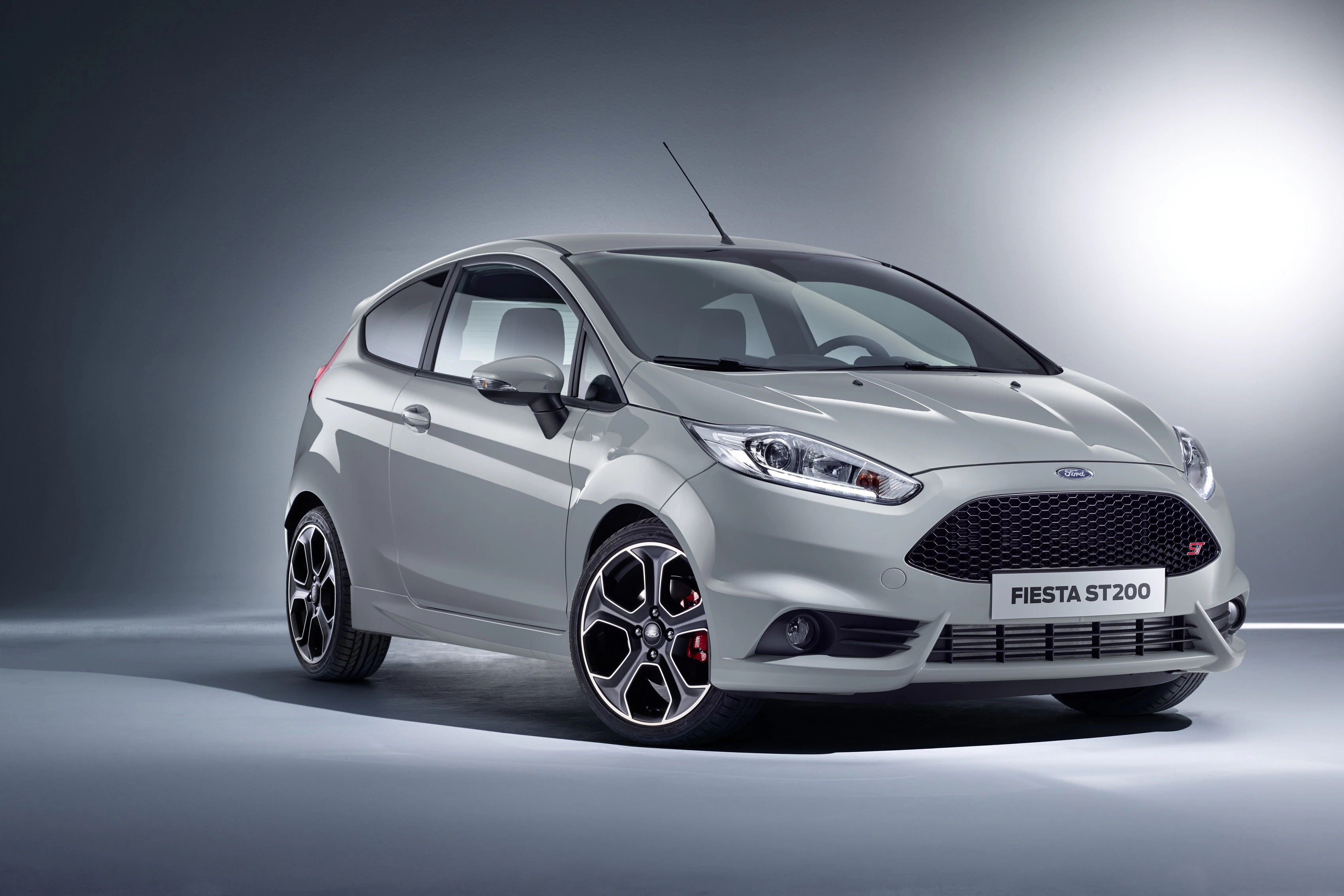Grauer Ford Fiesta ST200 in einem Studio, schräg von vorne fotografiert. Der Hintergrund ist schlicht und grau ausgeleuchtet.