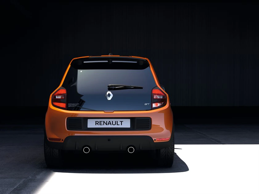 Orangefarbener Renault von hinten, parkt in dunkler Umgebung. Sichtbar sind Logo, Rücklichter und zwei Auspuffrohre.