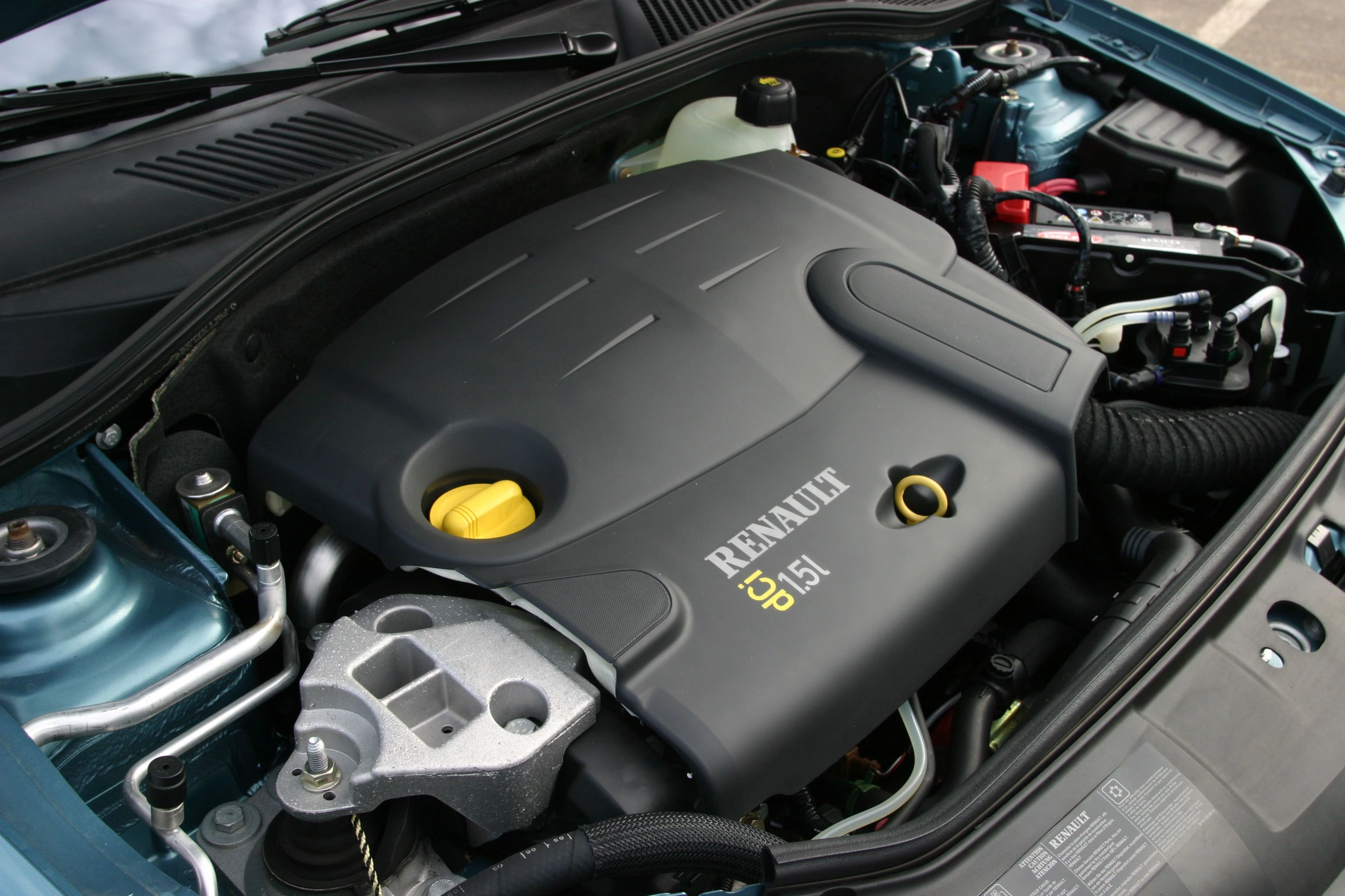 Motorraum eines Autos mit einem Renault-5,9-Liter-Dieselmotor. Sichtbare Schläuche und Kabel im Hintergrund.