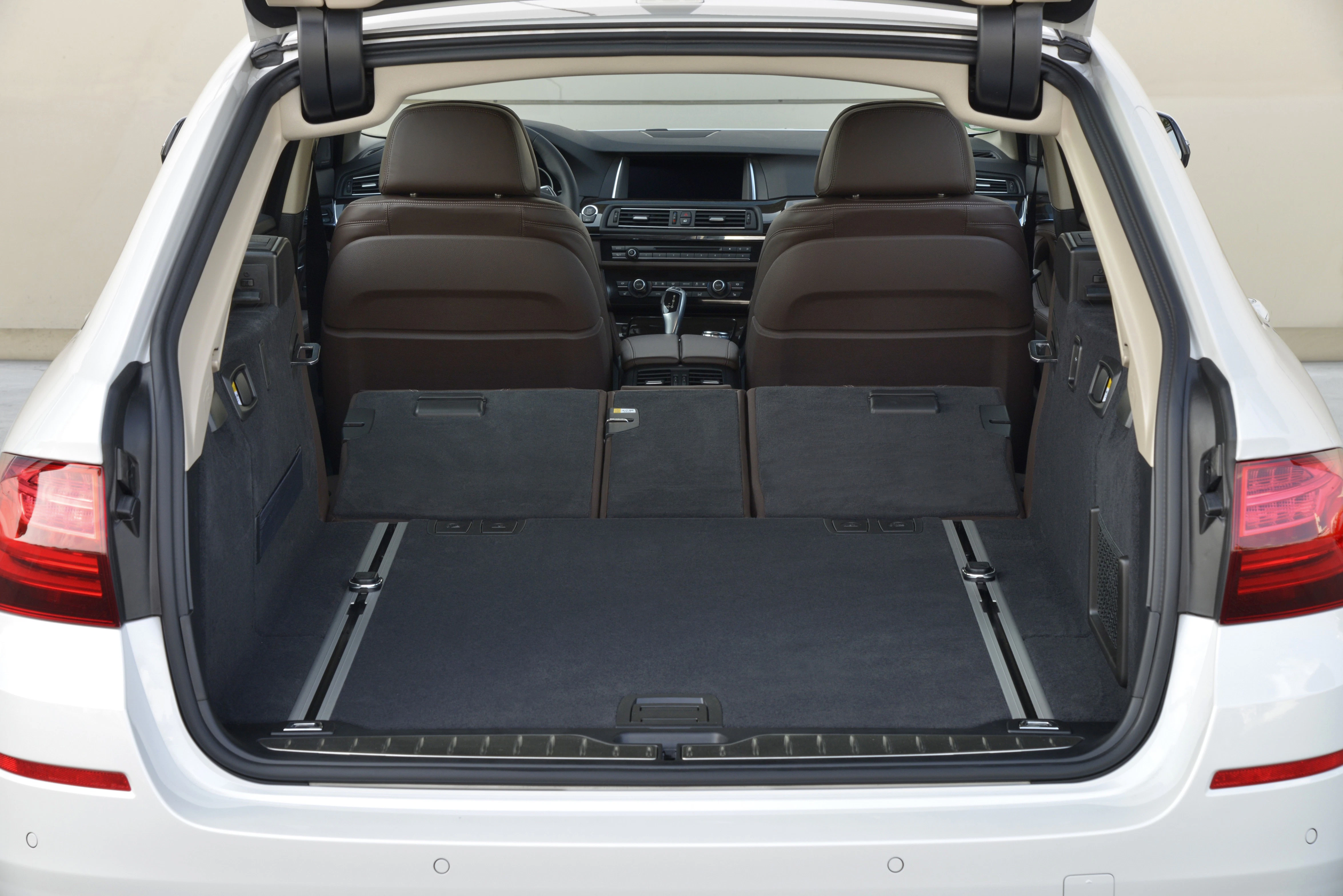Kofferraum eines weißen Autos mit umgeklappten Rücksitzen, zeigt viel Ladefläche und modernes Innenraumdesign.