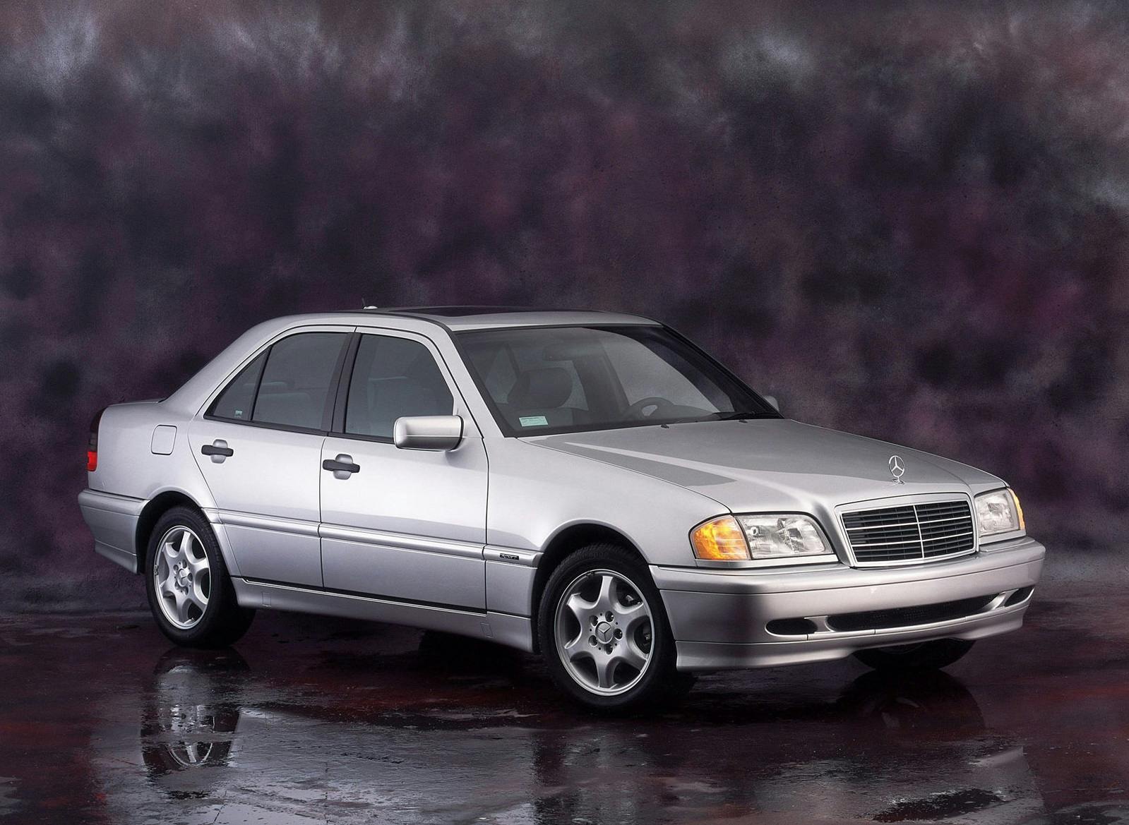 Silberner Mercedes-Benz-Limousine vor dunklem, verschwommenem Hintergrund, seitlich aufgenommen mit Klarheit und Eleganz.