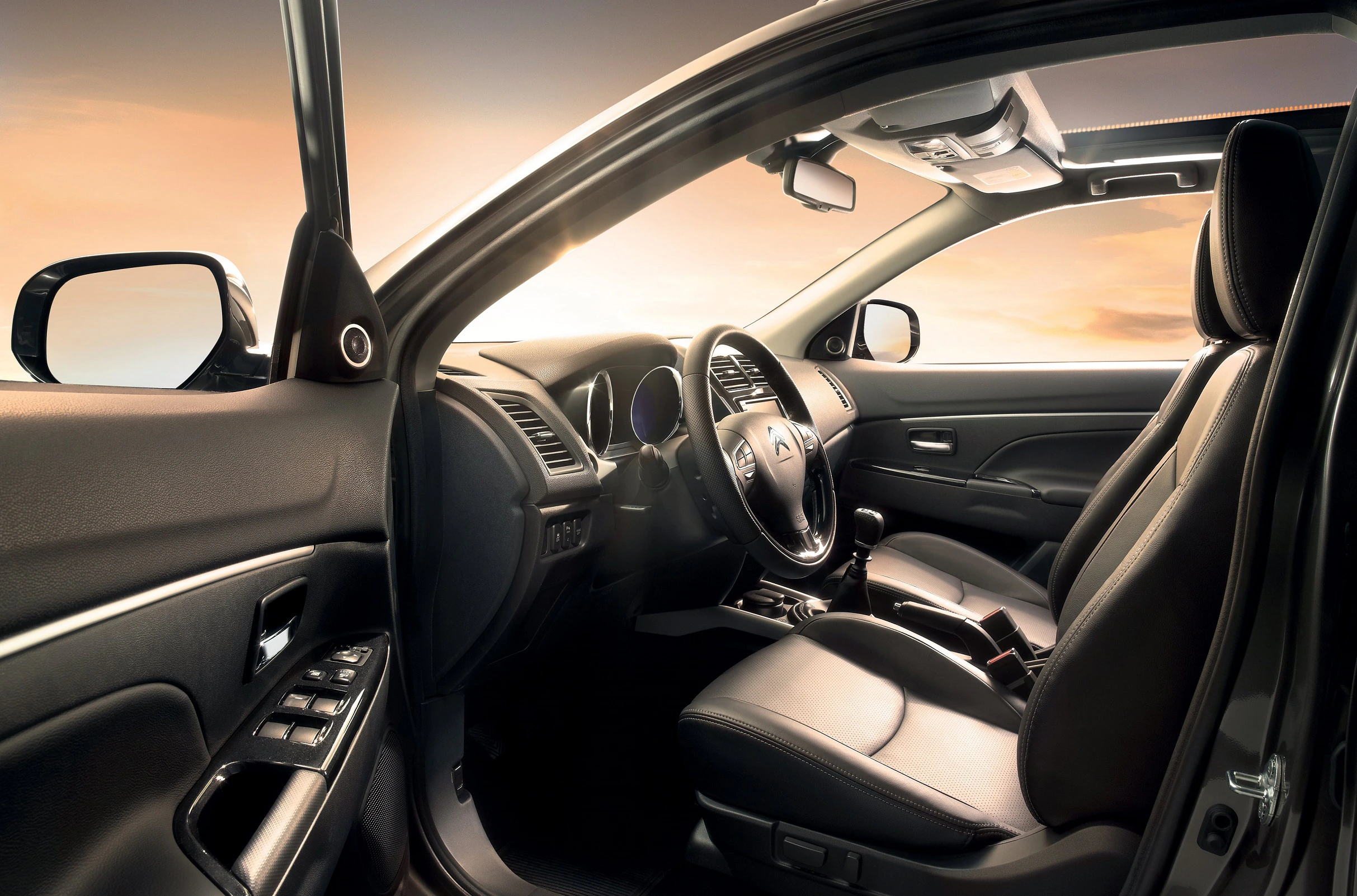 Innenansicht eines modernen Autos mit Ledersitzen, beleuchtet vom warmen Licht eines Sonnenuntergangs am Horizont.