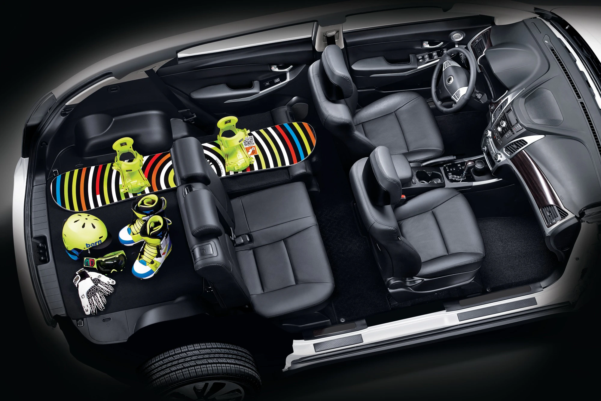 Innenansicht eines Autos mit einem Snowboard und Ausrüstungen auf den Rücksitzen. Modernes, geräumiges Design, Fokus auf Bequemlichkeit.