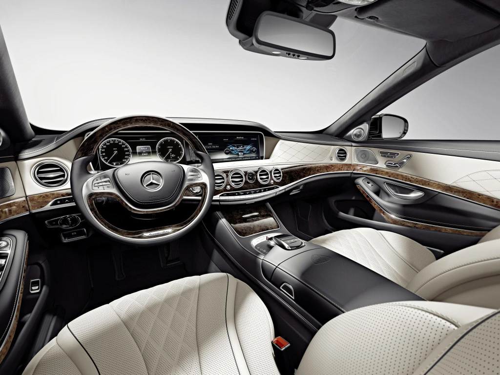 Luxuriöser Innenraum eines Autos mit Lederpolsterung, Holzverkleidung und modernem Armaturenbrett.