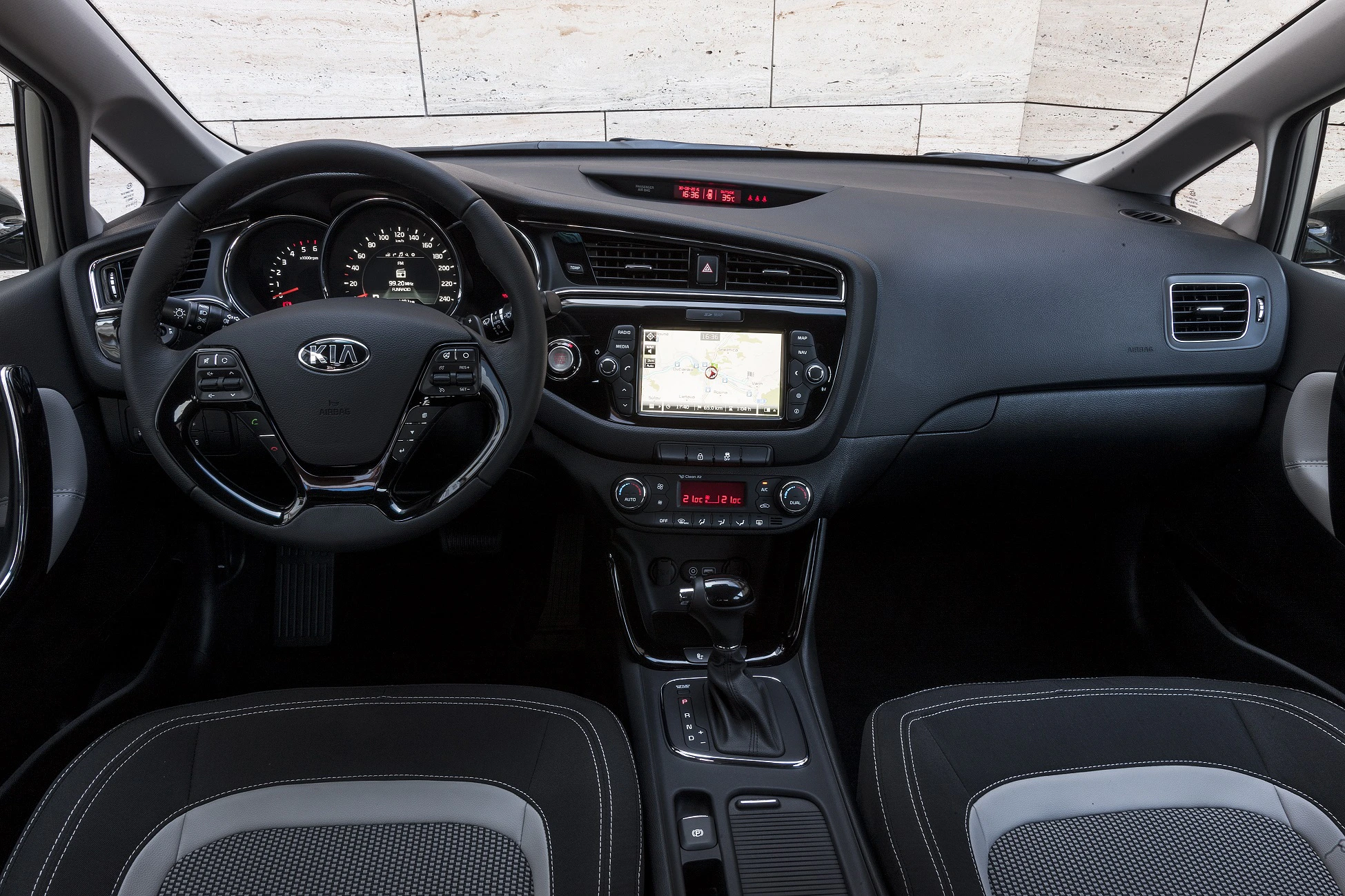 Innenraum eines Autos mit Multifunktionslenkrad, digitalem Armaturenbrett, großem Bildschirm und modernem Design in Schwarz und Grau.