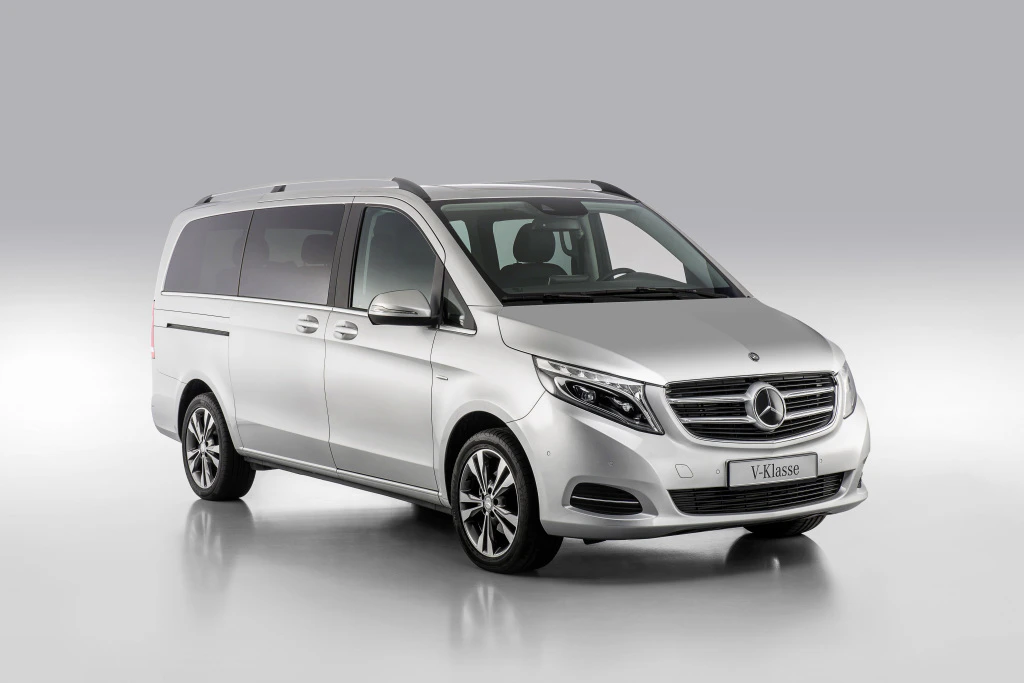Silberner Mercedes-Benz V-Klasse Van, seitliche Vorderansicht, auf grauem Hintergrund.