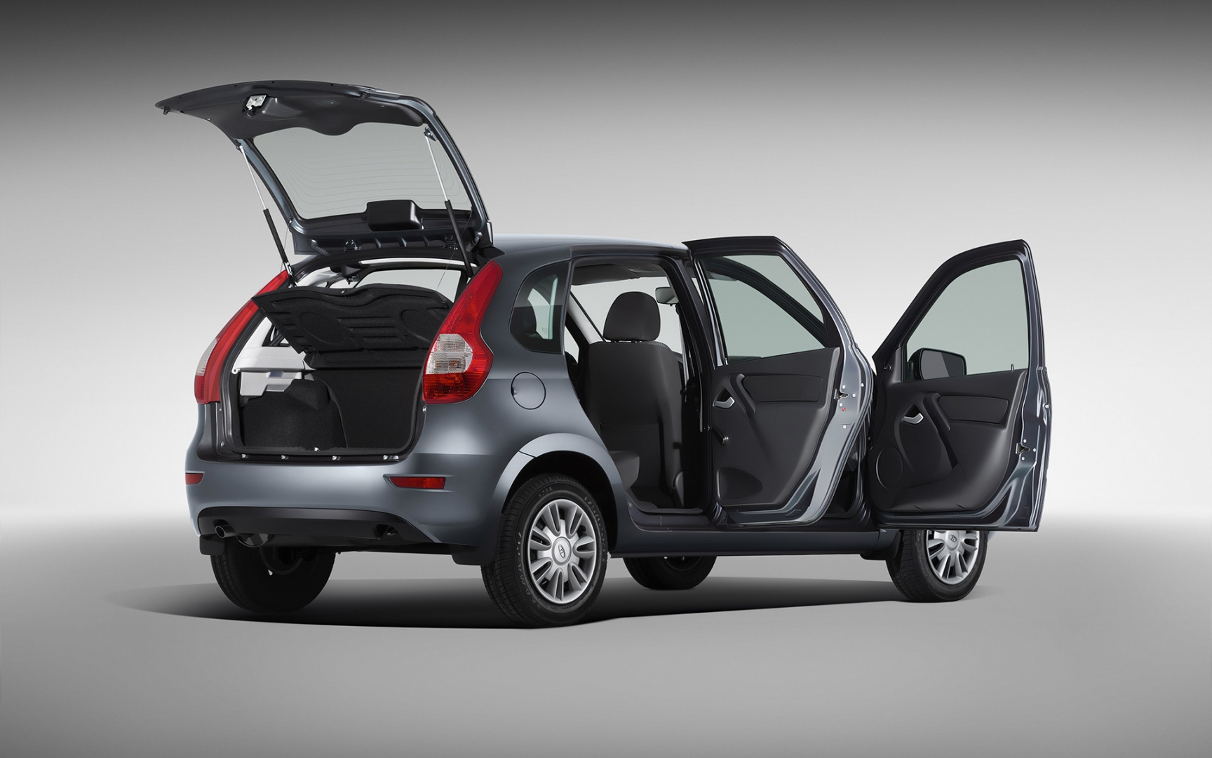 Kleines Auto in Silber mit geöffneten Türen und Kofferraum, präsentiert in einem Studio vor grauem Hintergrund.