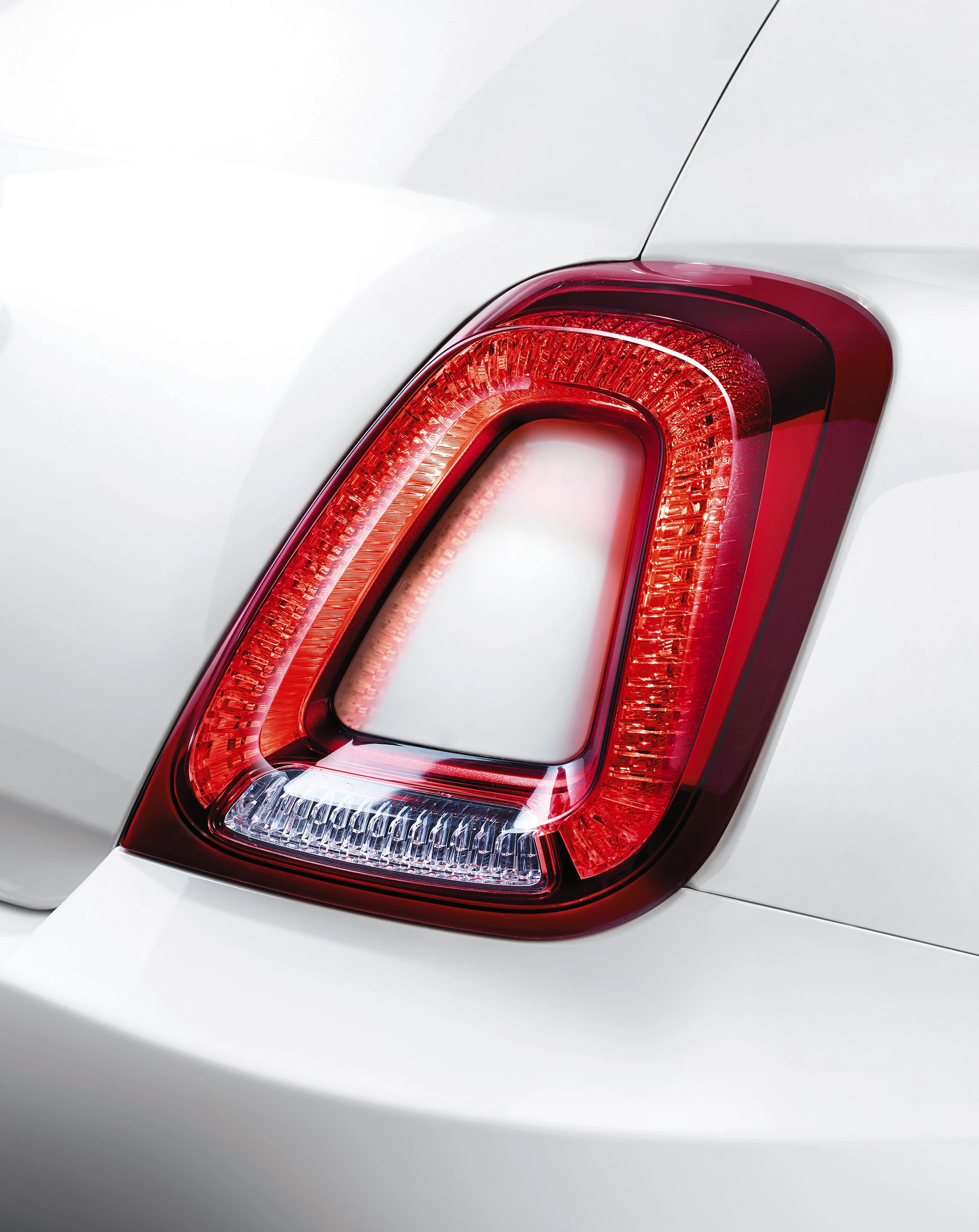 Nahaufnahme eines Rücklichts eines weißen Fahrzeugs mit markantem, modernem Design.