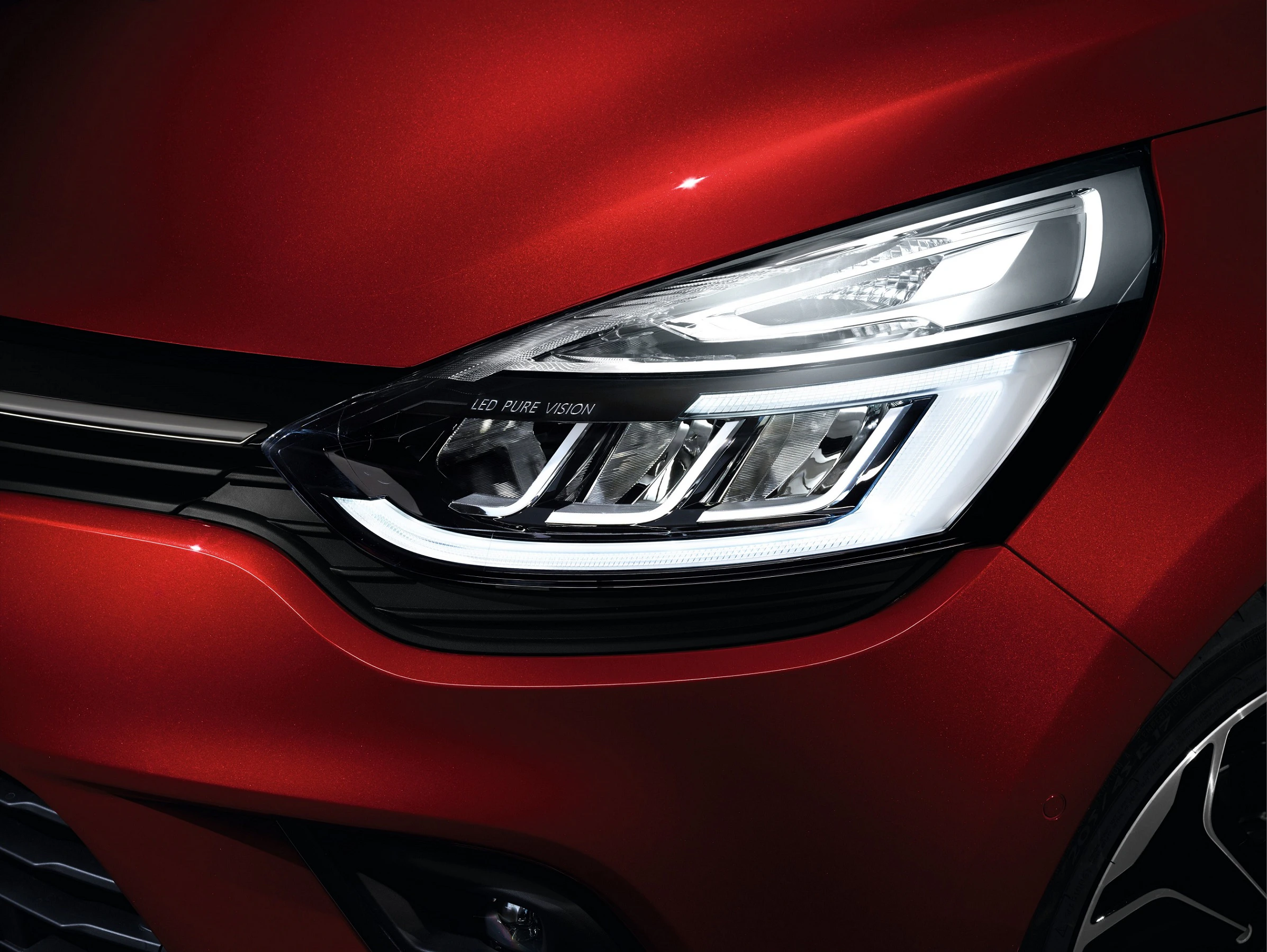 Nahaufnahme eines roten Autoscheinwerfers mit LED-Technologie, glänzendem Finish und elegantem Design.