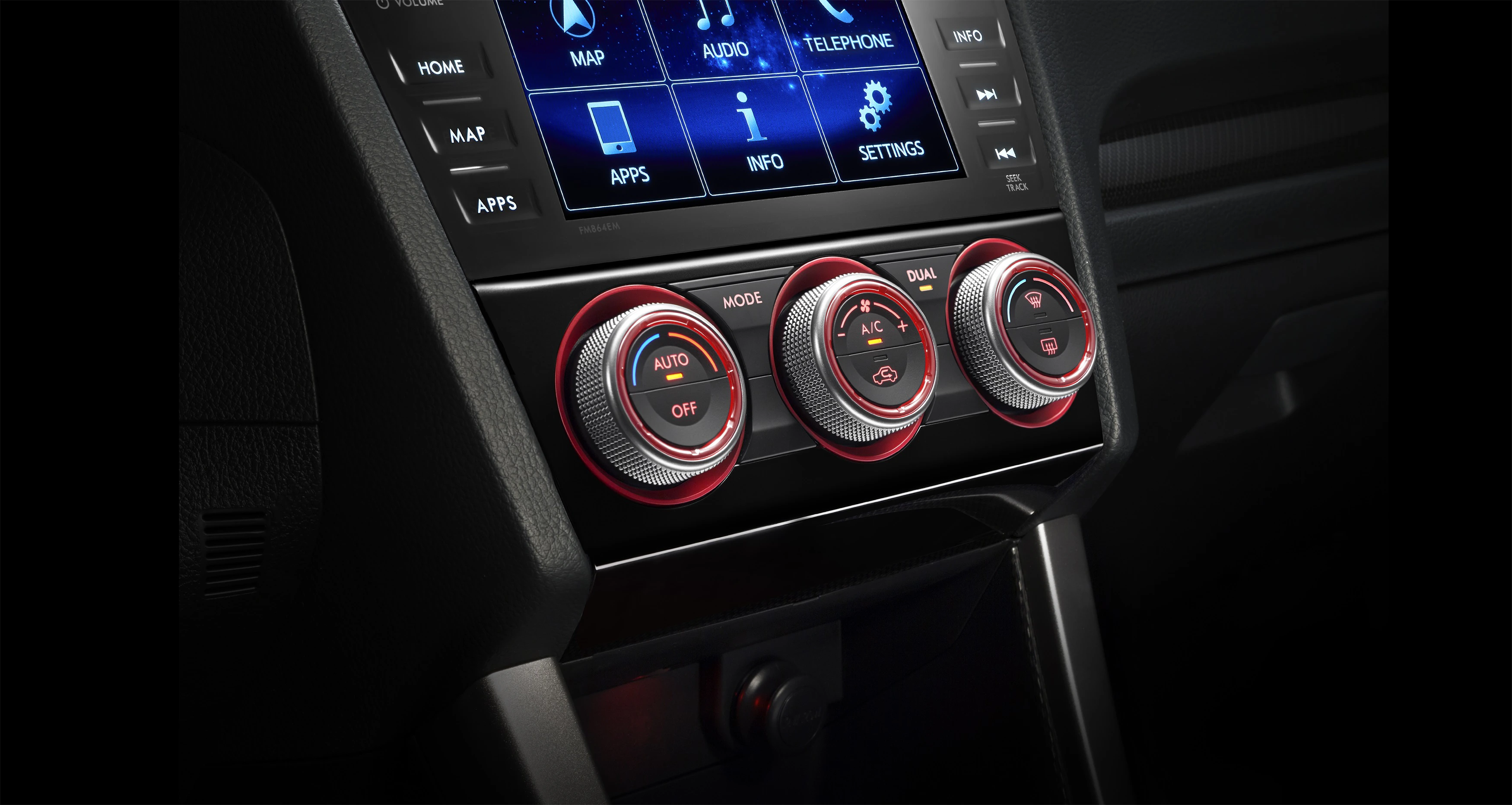 Nahaufnahme einer Fahrzeug-Klimaanlage mit drei Drehknöpfen, umgeben von roten Ringen. Darüber befindet sich ein Touchscreen-Display.