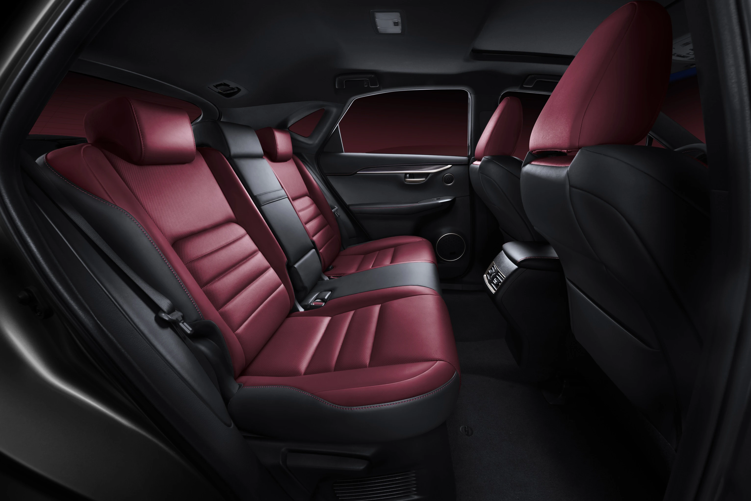 Innenraum eines Autos mit roten Ledersitzen und schwarzem Armaturenbrett. Rückbank mit gutem Beinraum und modernen Designelementen.